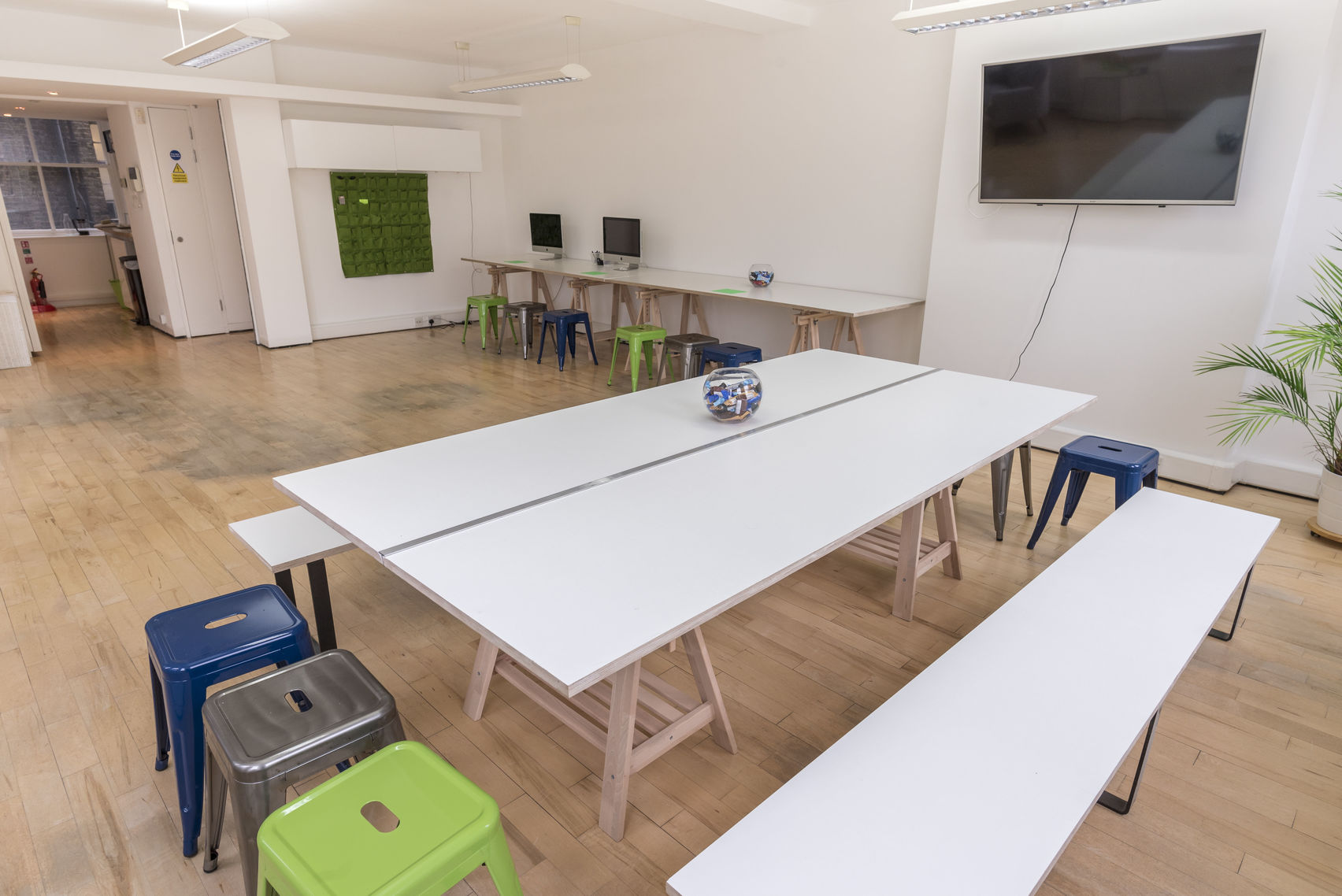 Versatile meeting space with large table, ideal for workshops and brainstorming sessions.