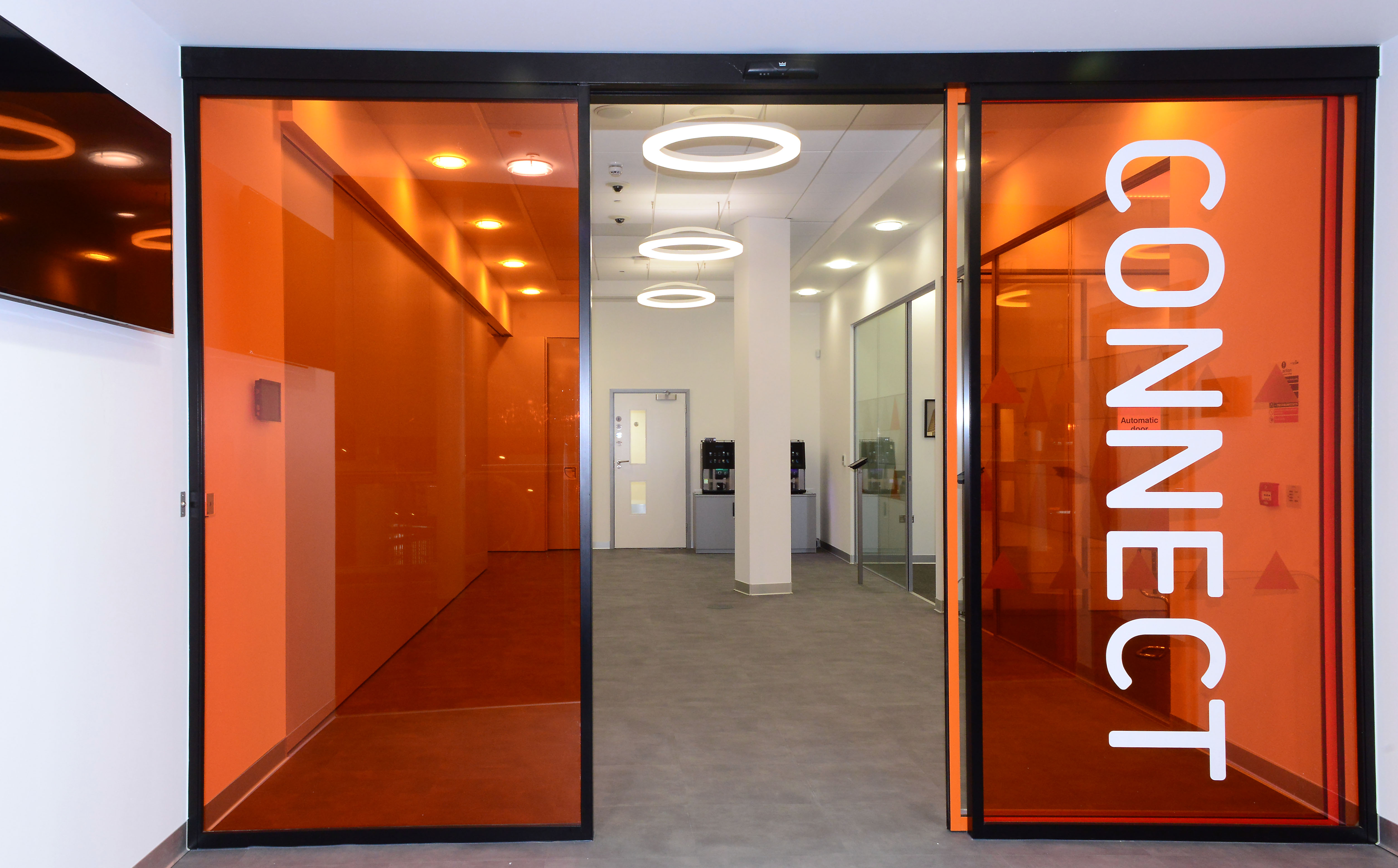 Modern CONNECT Event Space entrance with orange glass doors, ideal for networking events.
