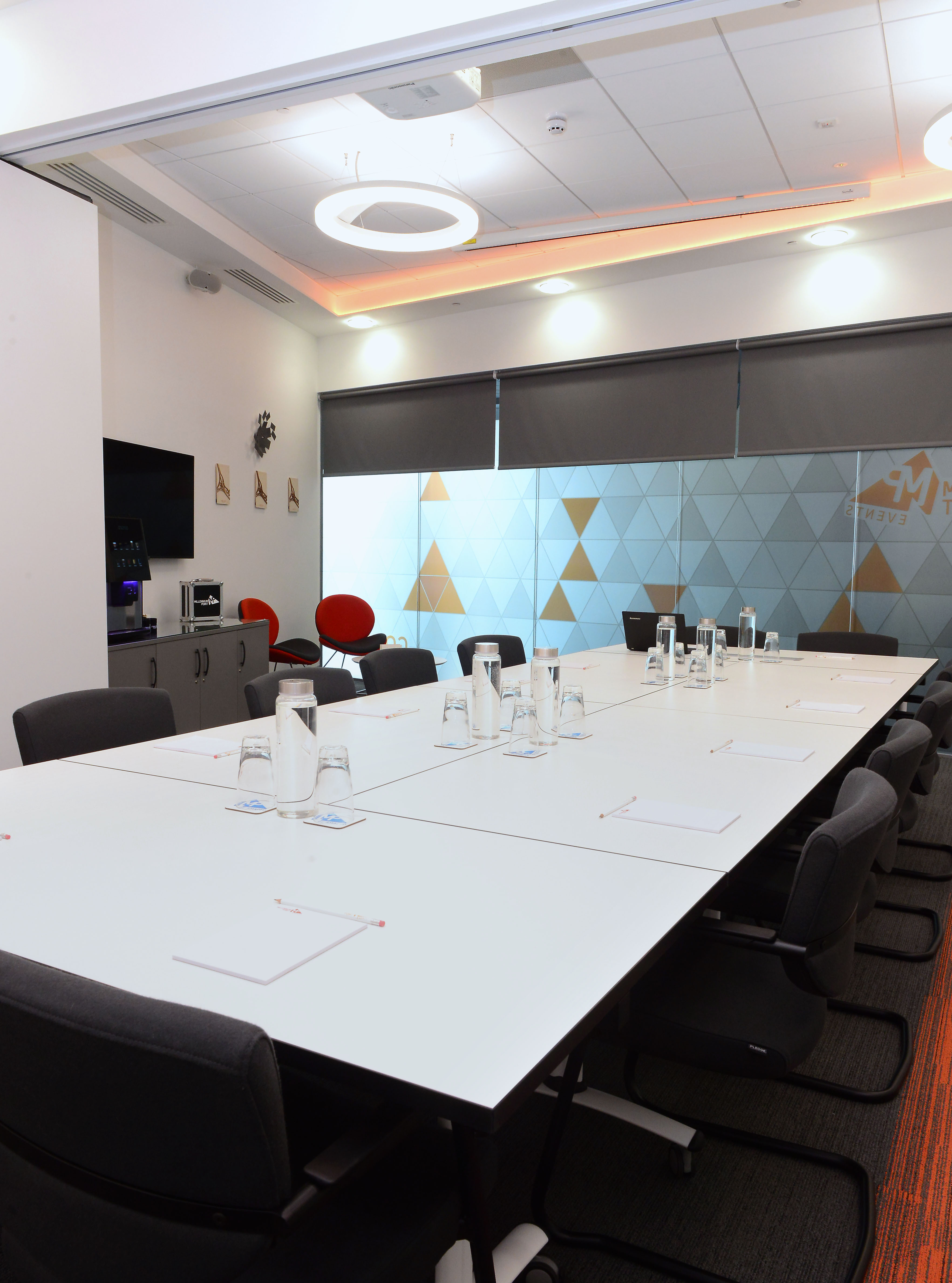 Modern meeting room with long table, ideal for professional gatherings and hybrid events.