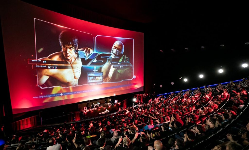 Packed auditorium at Millennium Point hosting an exciting esports event with large screen.