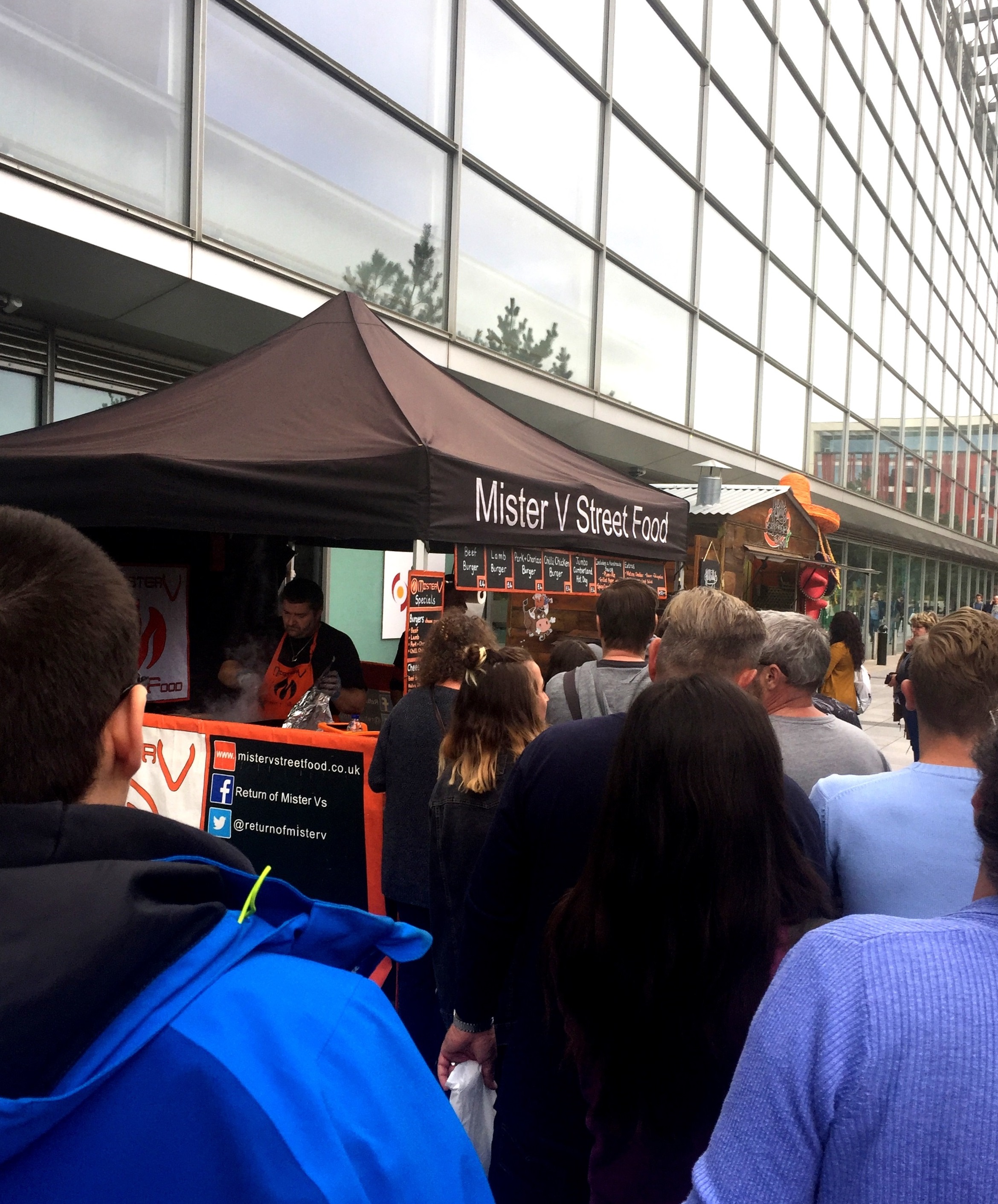 Bustling street food stall at Millennium Point event with long queue, perfect for festivals.