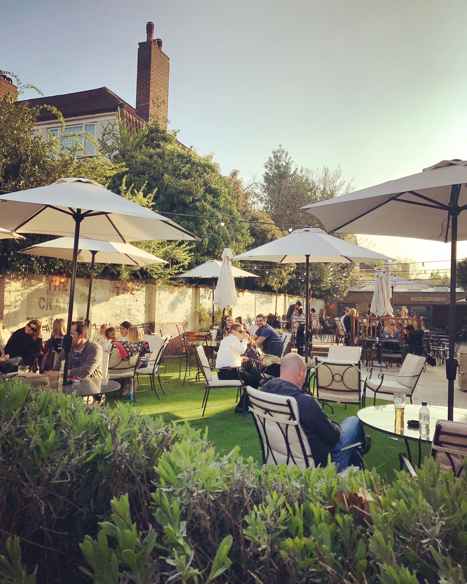 Trinity Room outdoor event space with tables, umbrellas, and greenery for gatherings.