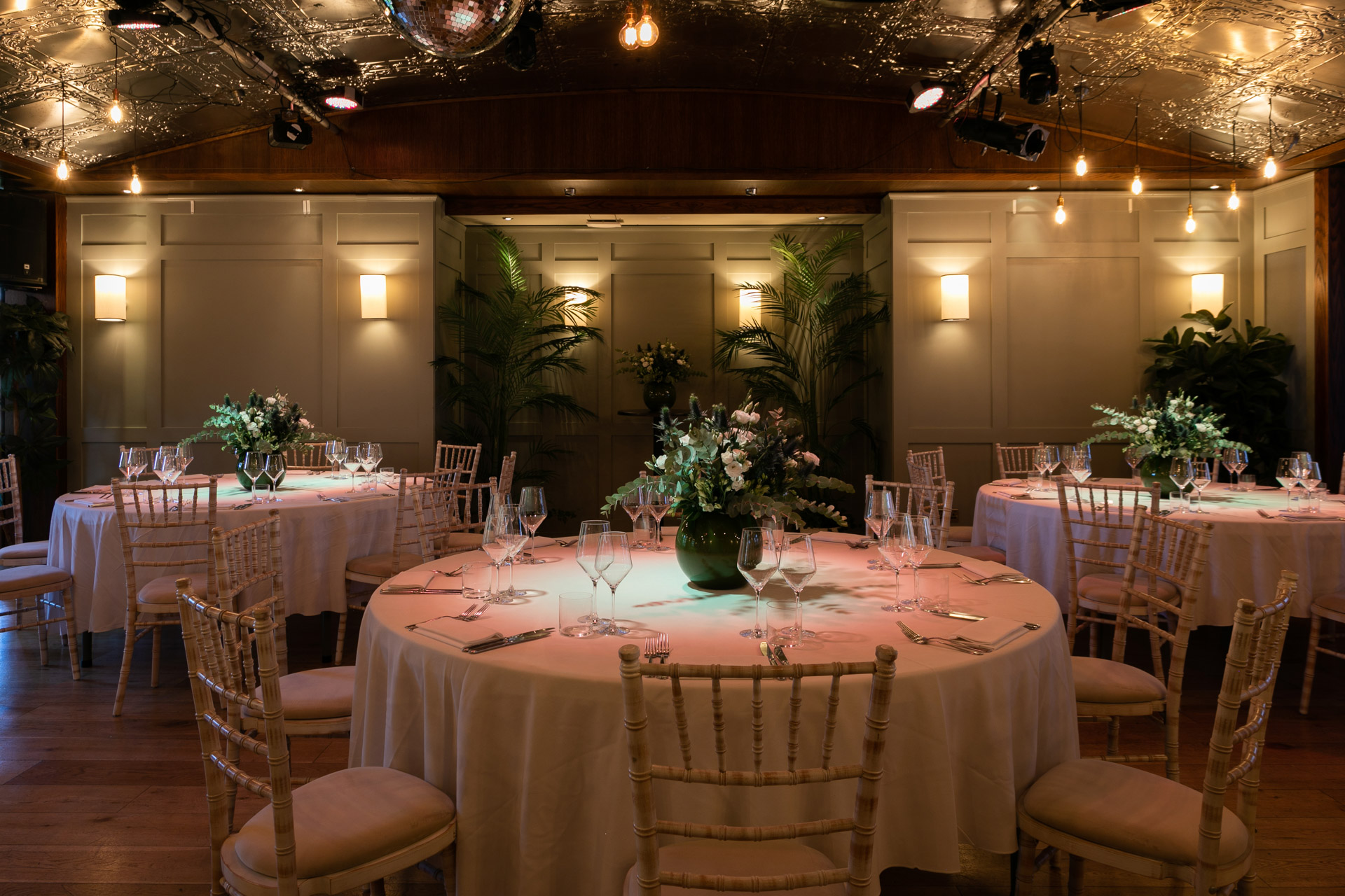 Elegant Green Room at Century Club with round tables, ideal for upscale events and gatherings.