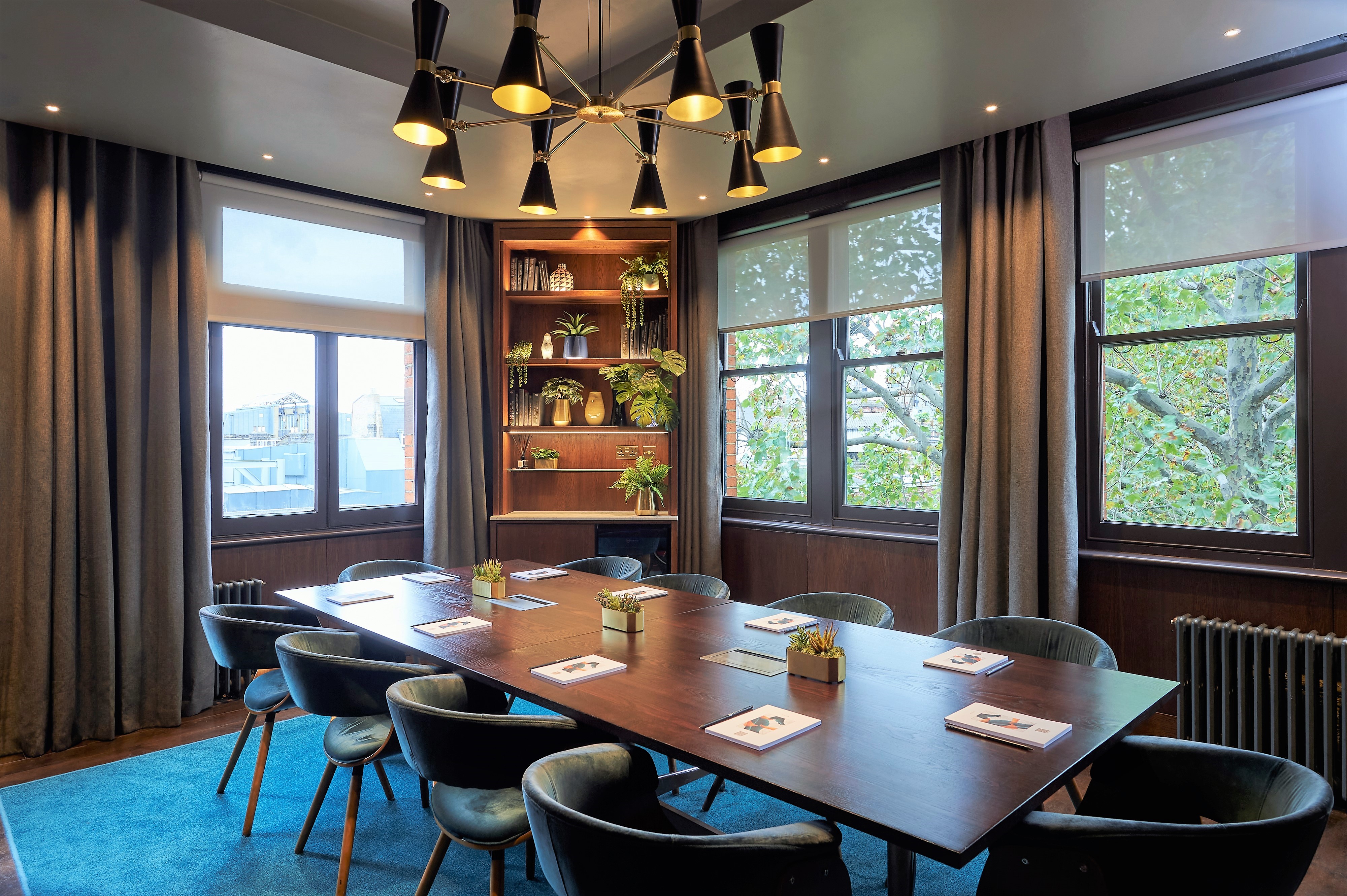 Modern meeting room at The Compton, featuring a large wooden table for gatherings.