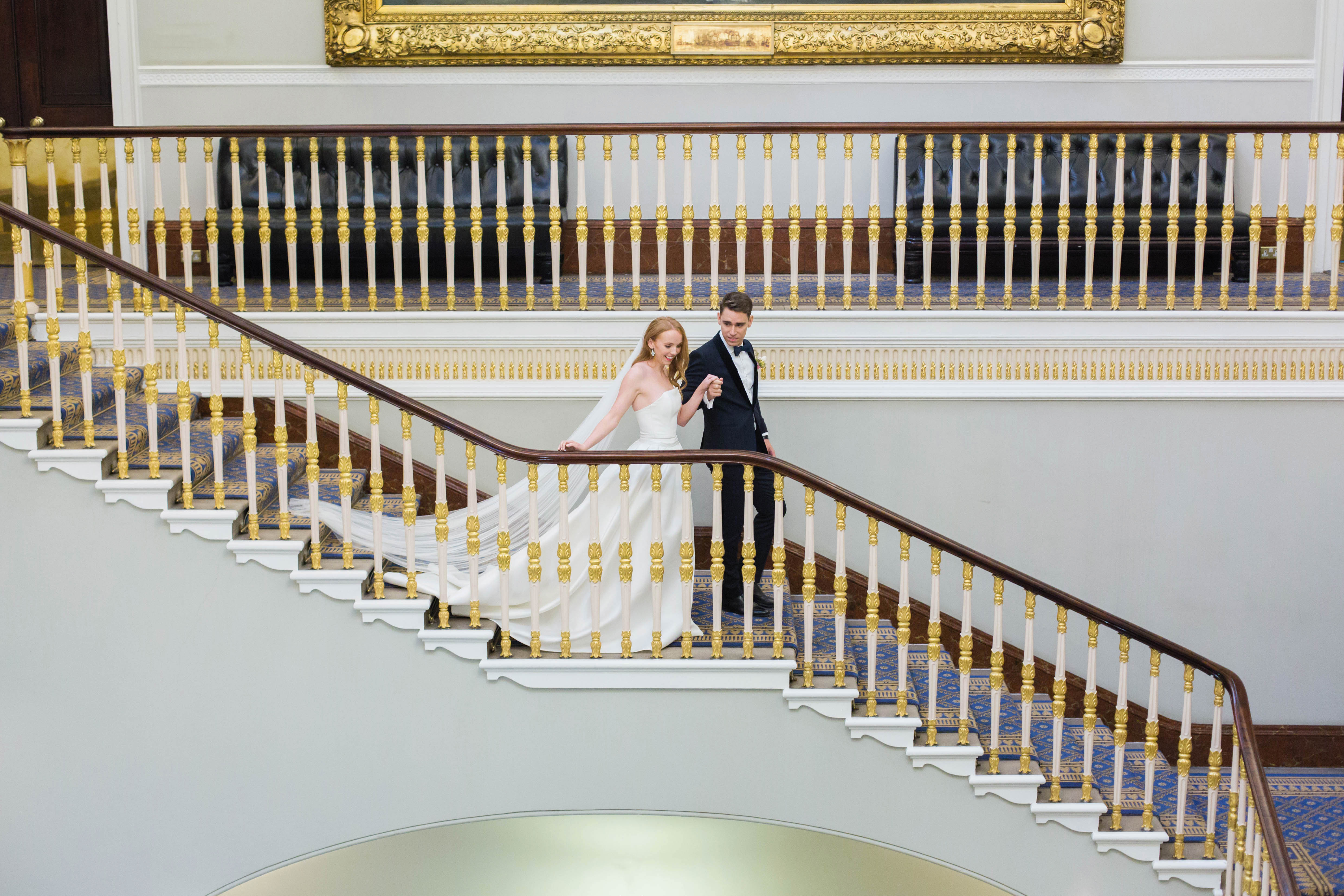 Elegant couple ascending grand staircase at Carlton Room, perfect for weddings and upscale events.