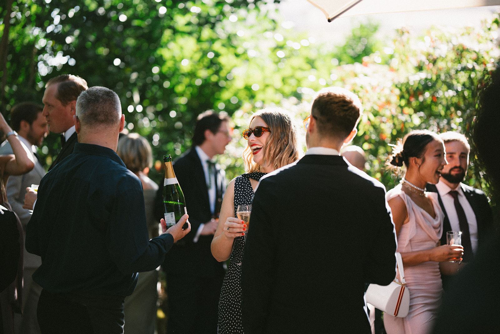 Outdoor networking event in Carlton Room, 116 Pall Mall, with lush greenery and stylish guests.