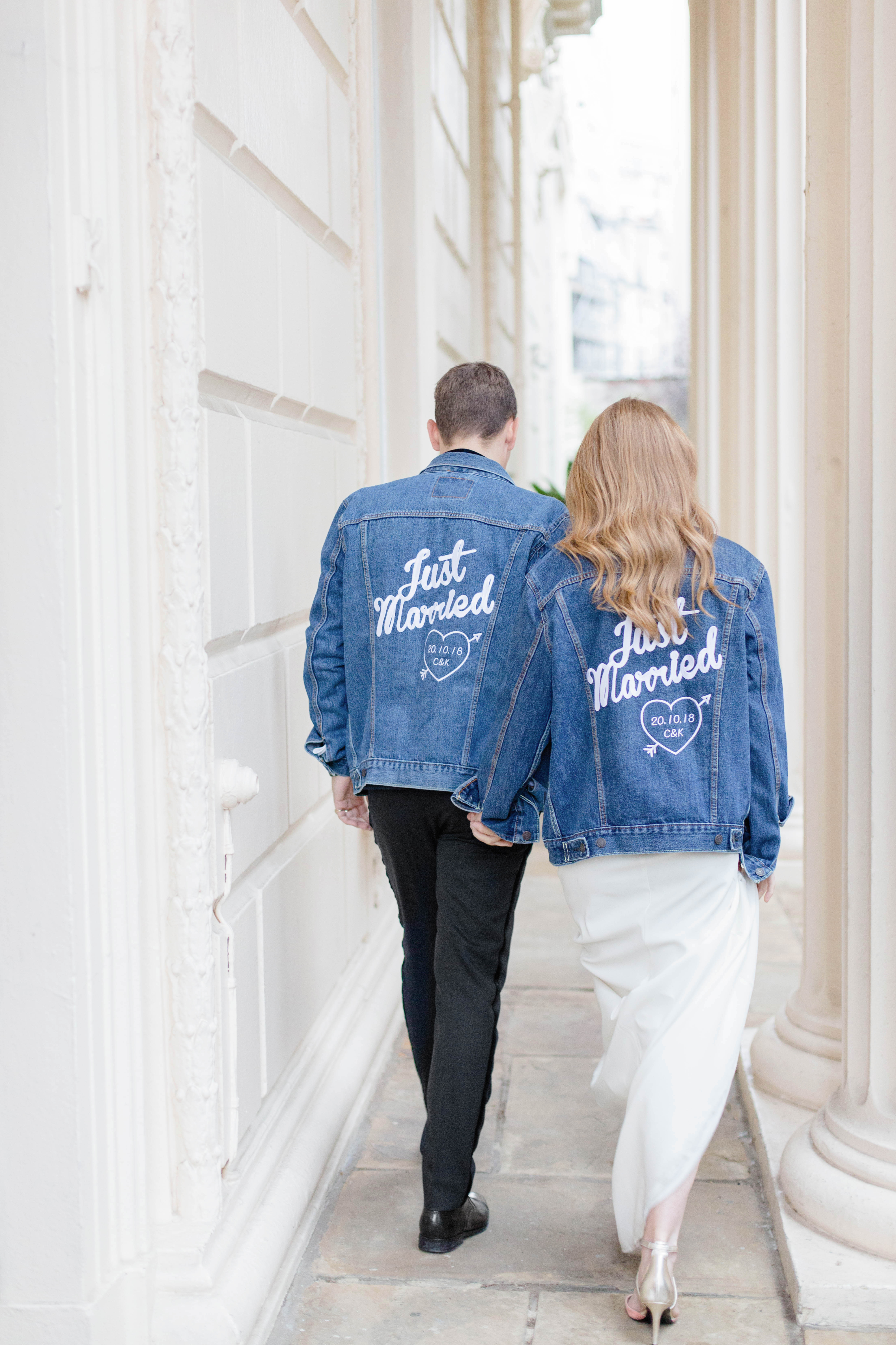 Stylish couple in matching "Just Married" denim jackets at Carlton Room wedding.