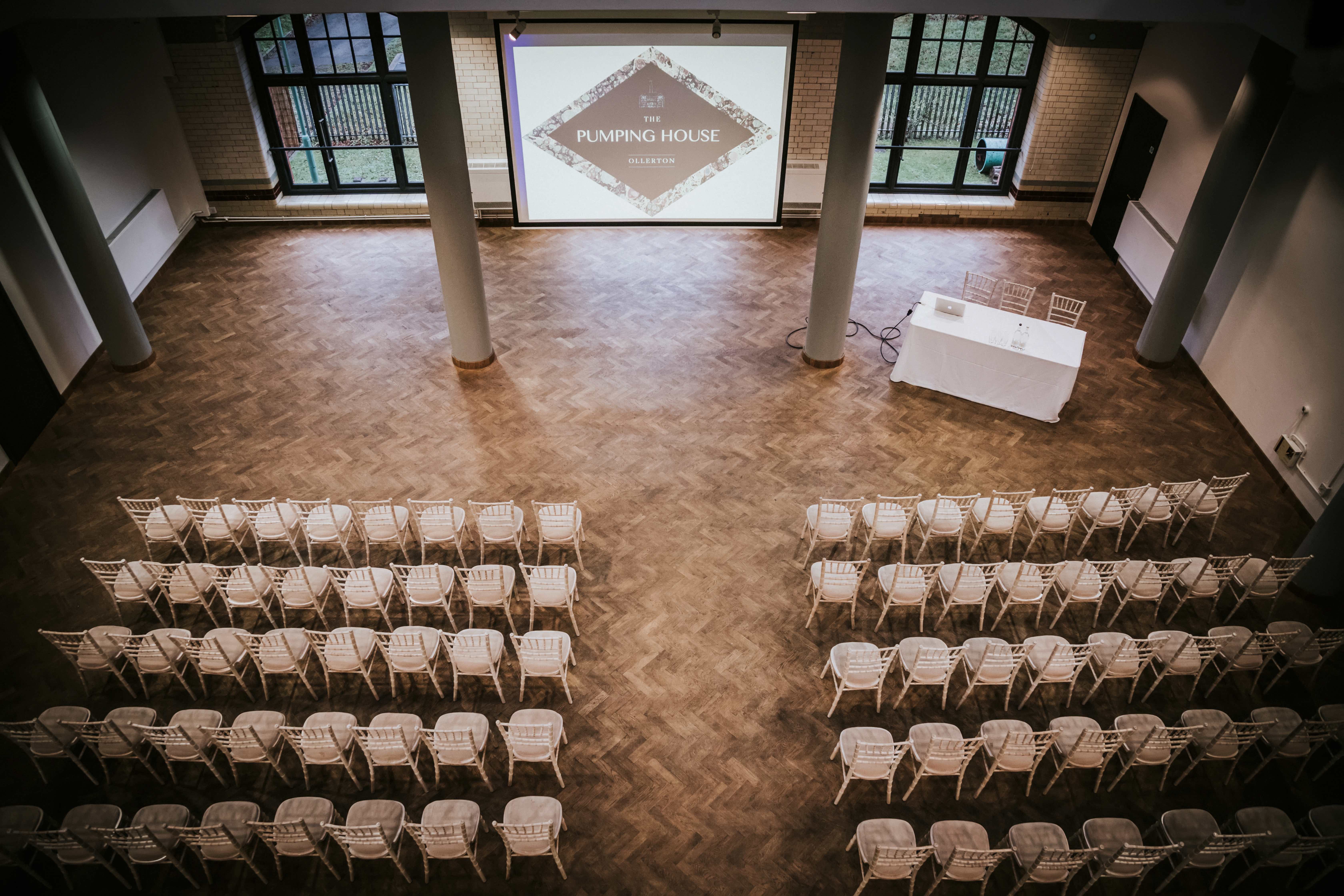 Spacious Engine Hall venue with chairs for presentations and natural light.