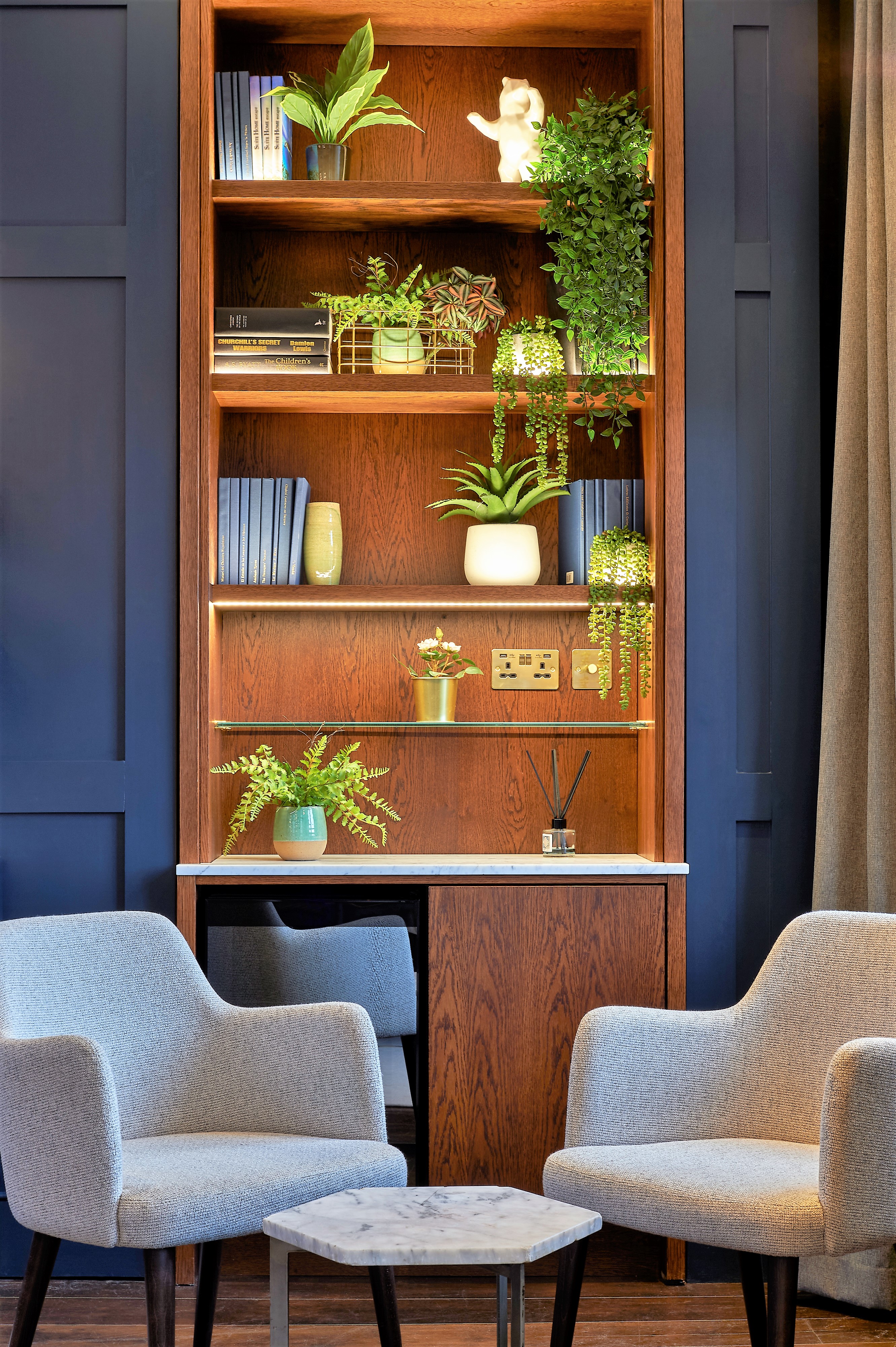 Stylish meeting space at The Shaftesbury with wooden shelves and greenery for events.