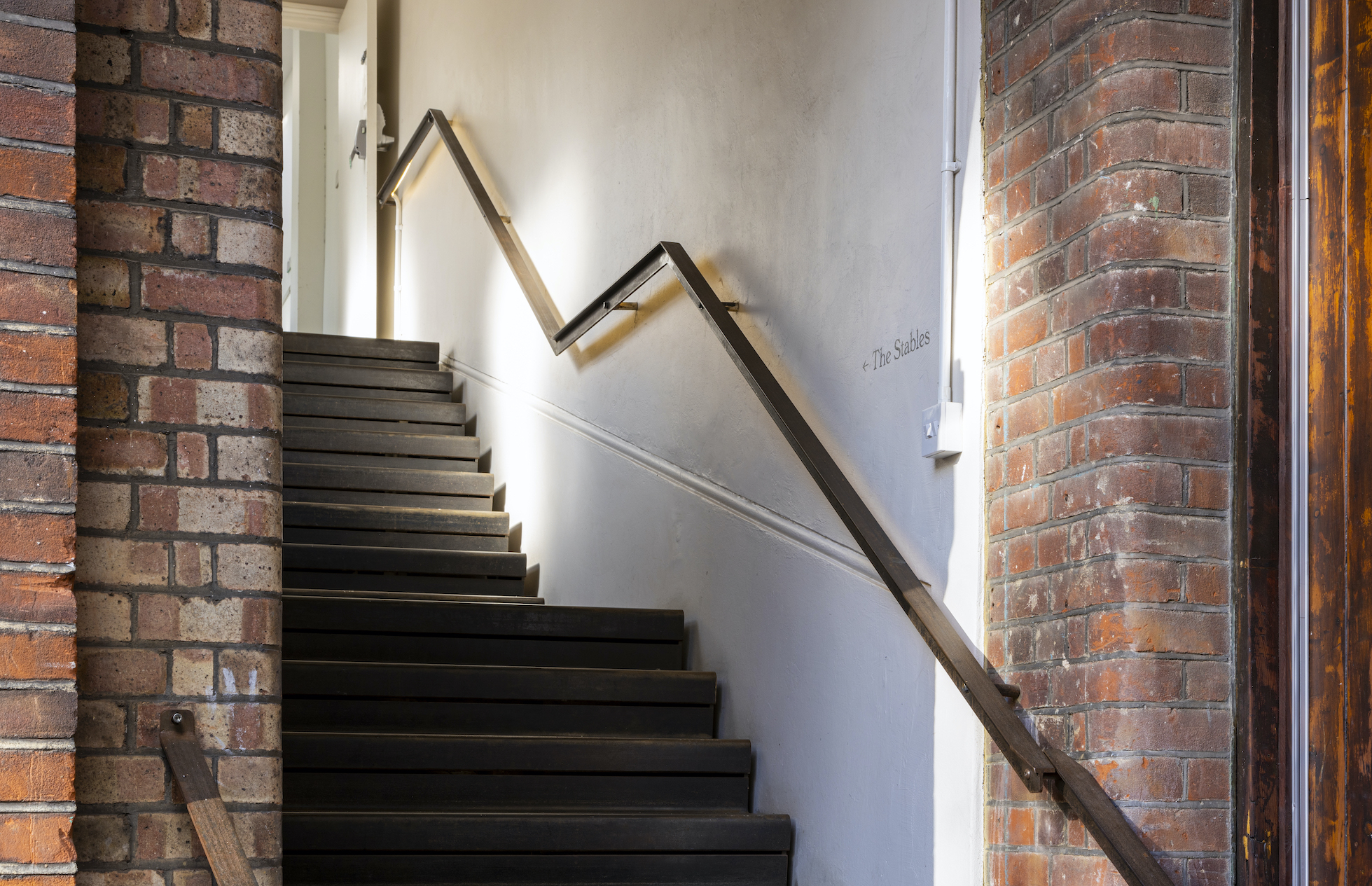 Well-lit staircase at The Stables, Park Village; ideal for events and meetings.