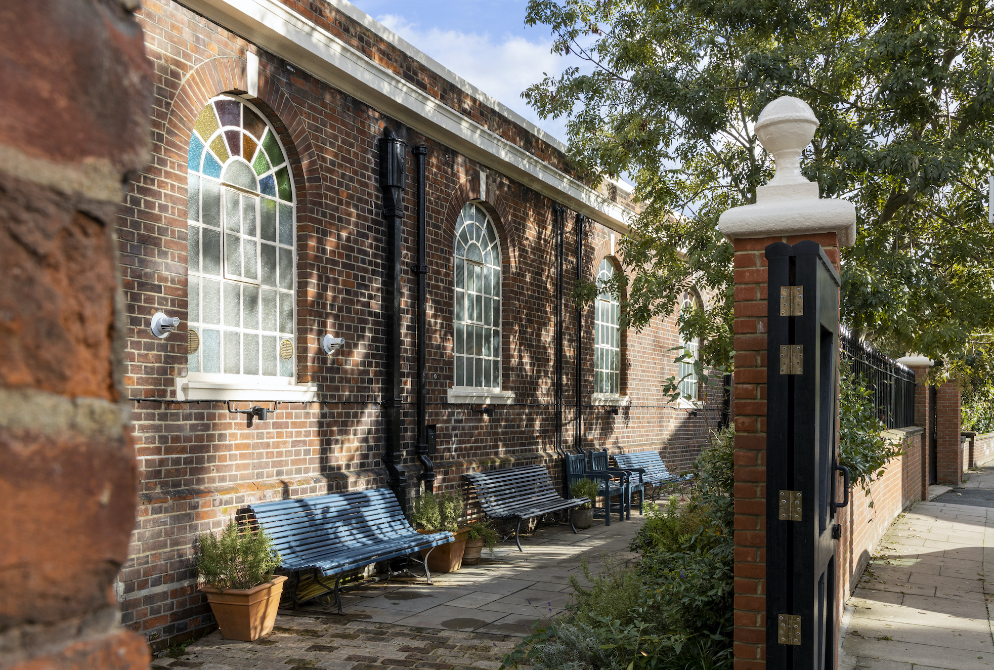 Charming outdoor venue with stained glass, perfect for networking events and gatherings.