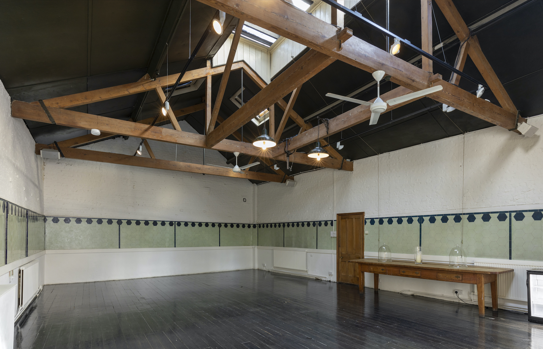 Spacious event space with high ceilings in The Stables, Park Village for workshops and gatherings.