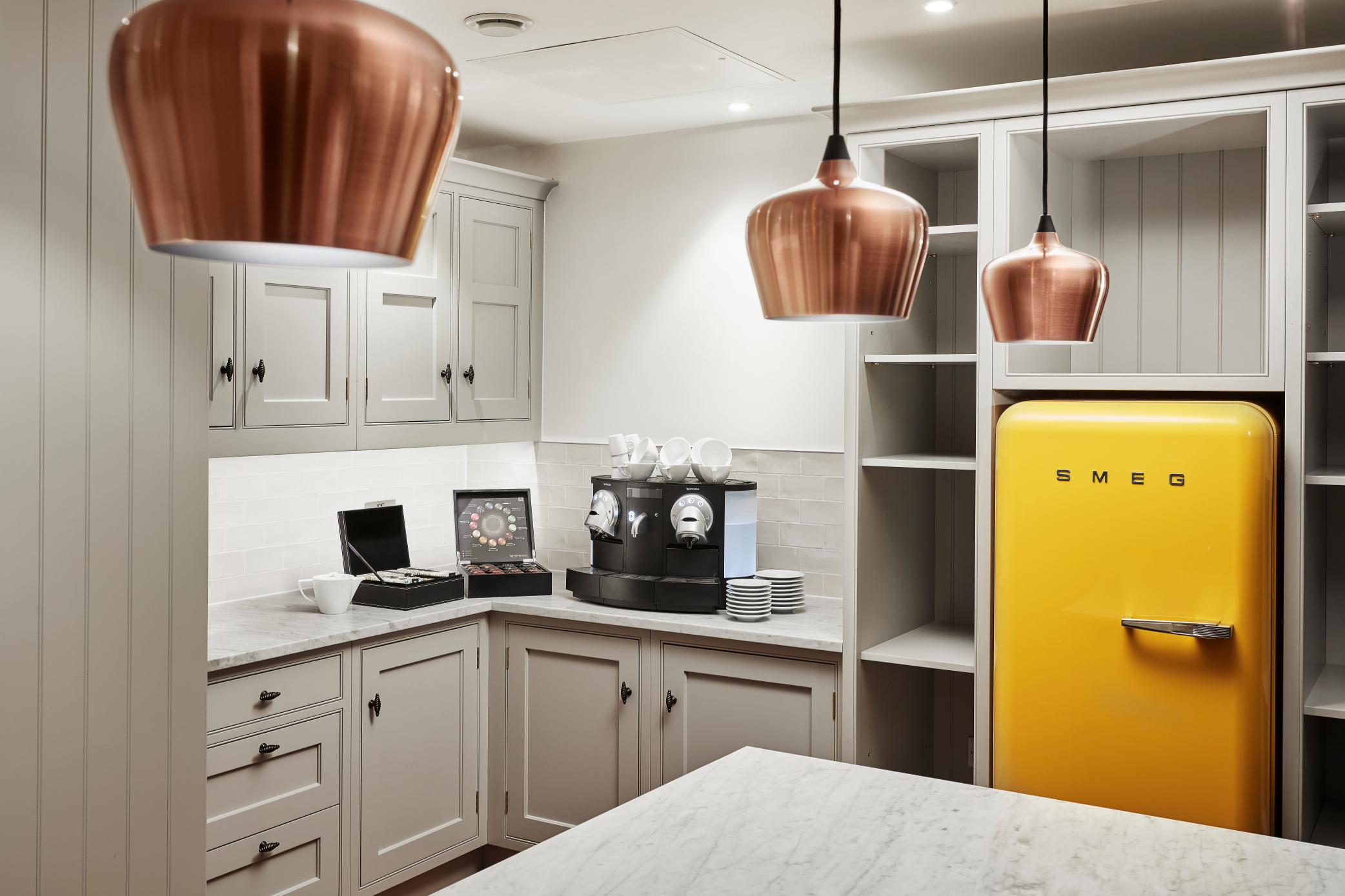 Stylish kitchenette with yellow SMEG fridge, perfect for meetings and networking events.