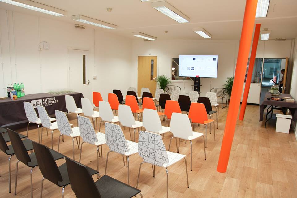 Modern event space with colorful chairs and a large screen in East London.