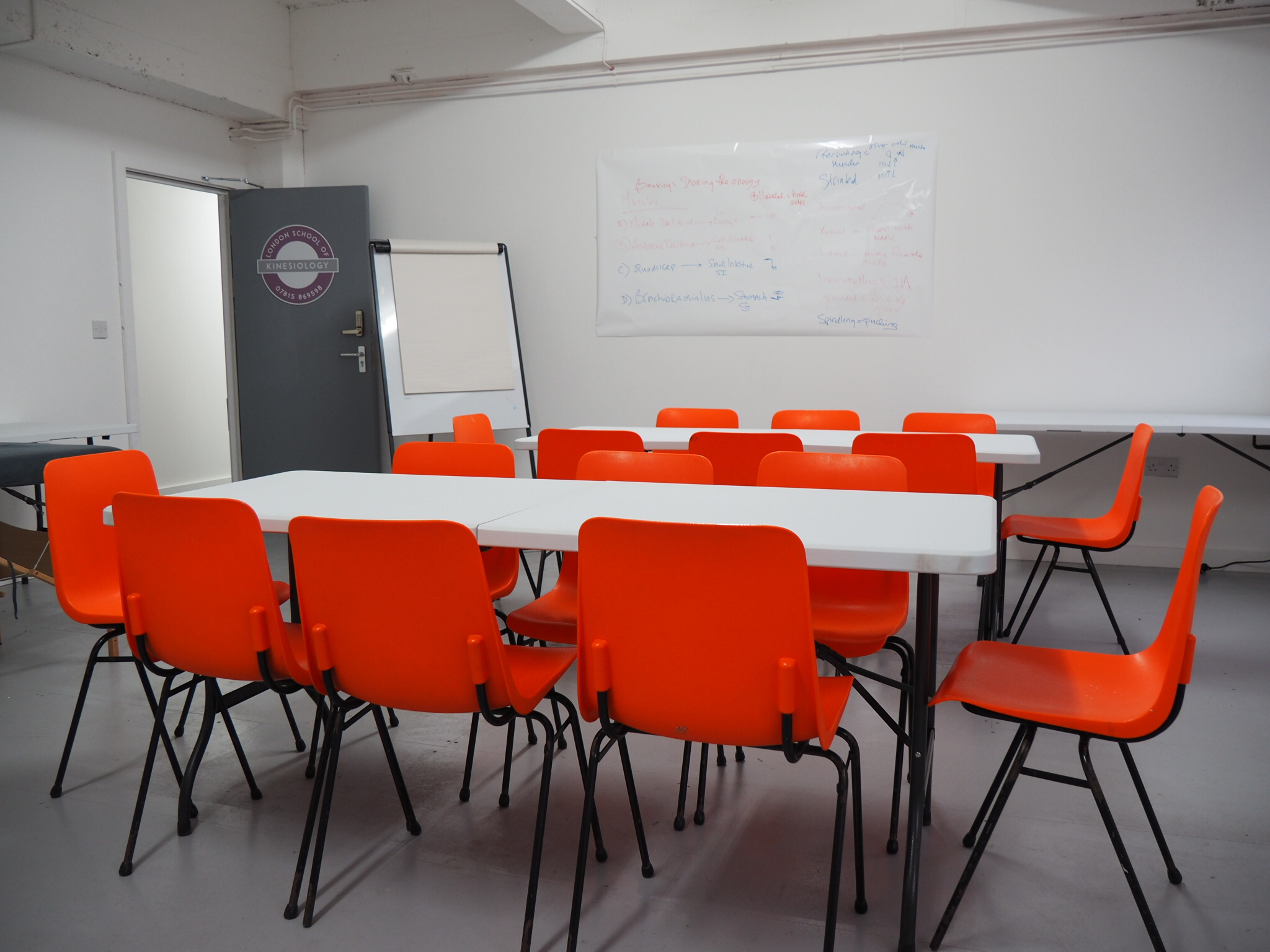 Modern meeting space with orange chairs, ideal for workshops and team meetings.
