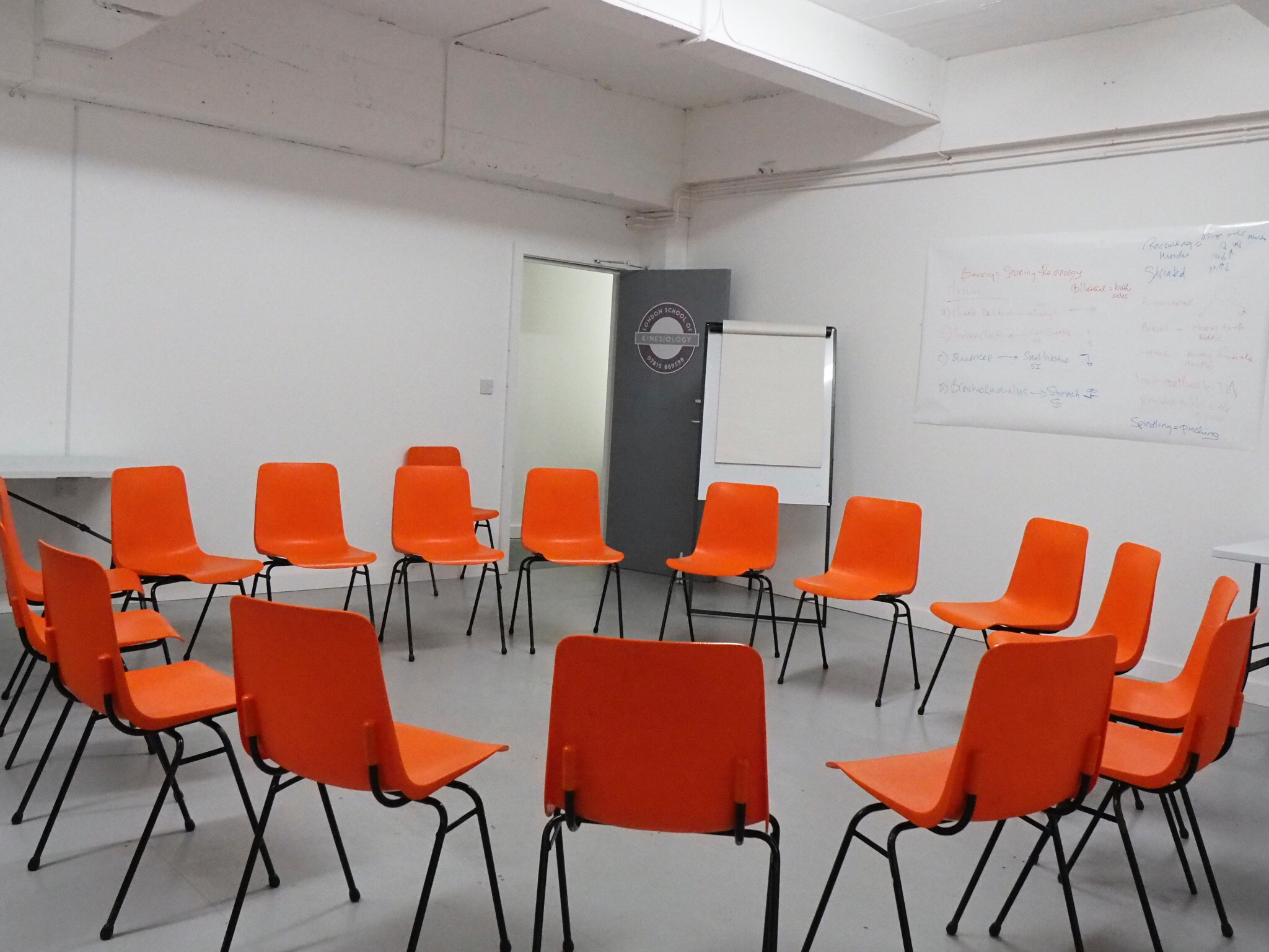 Versatile meeting space with orange chairs for workshops and brainstorming sessions.