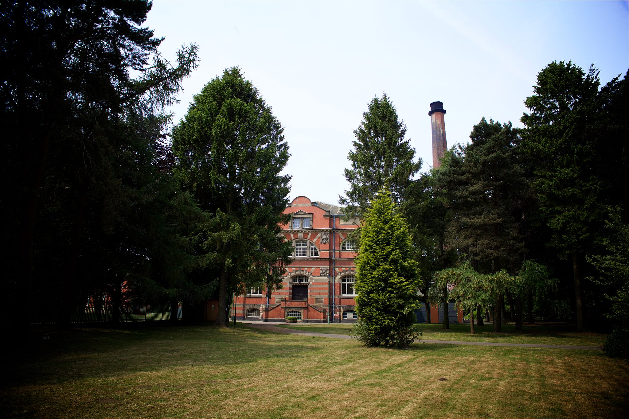 Charming brick venue for outdoor events, surrounded by lush greenery at The Pumping House.