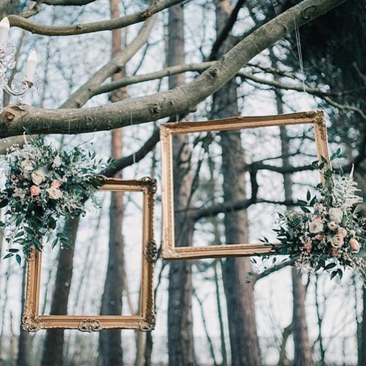 Outdoor wedding setup with gold frames and floral arrangements at The Pumping House.