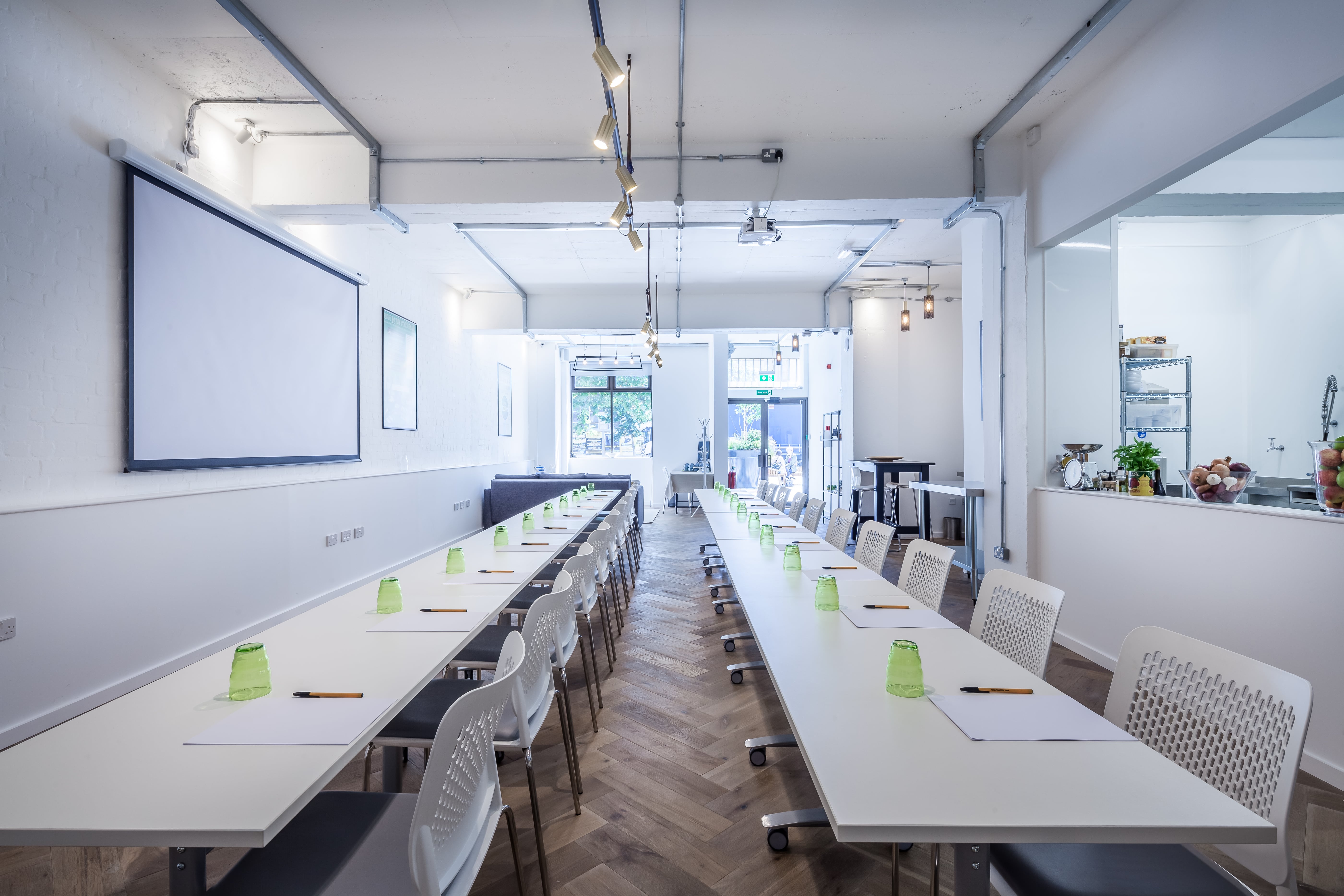 Modern meeting space with long tables, ideal for workshops and corporate meetings.