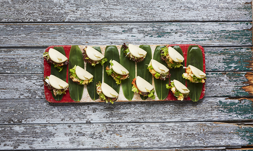 Mini sandwiches on banana leaves for stylish outdoor events at Upstairs Lounge.