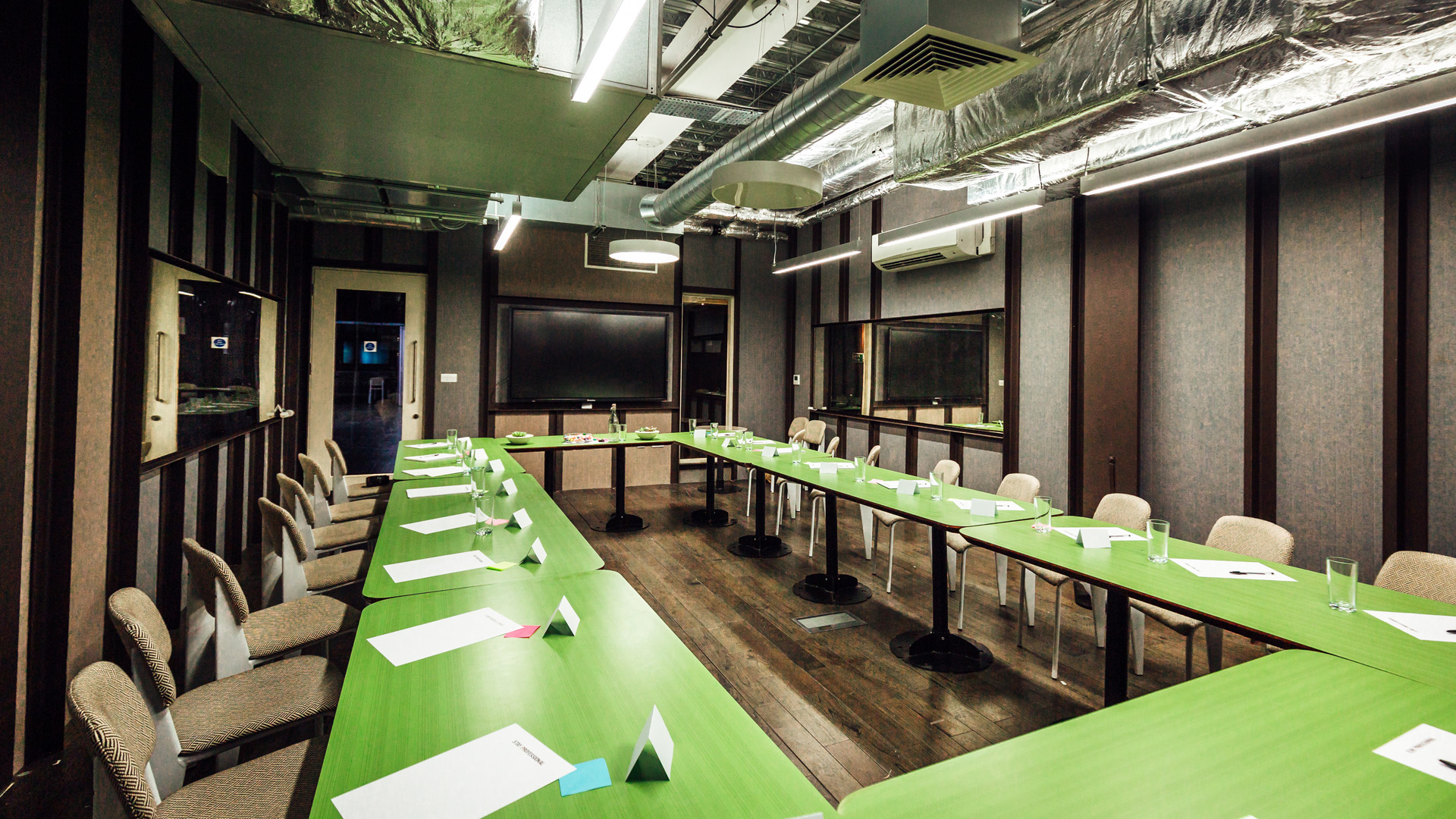 Modern meeting room with U-shaped table, ideal for workshops and strategic planning.