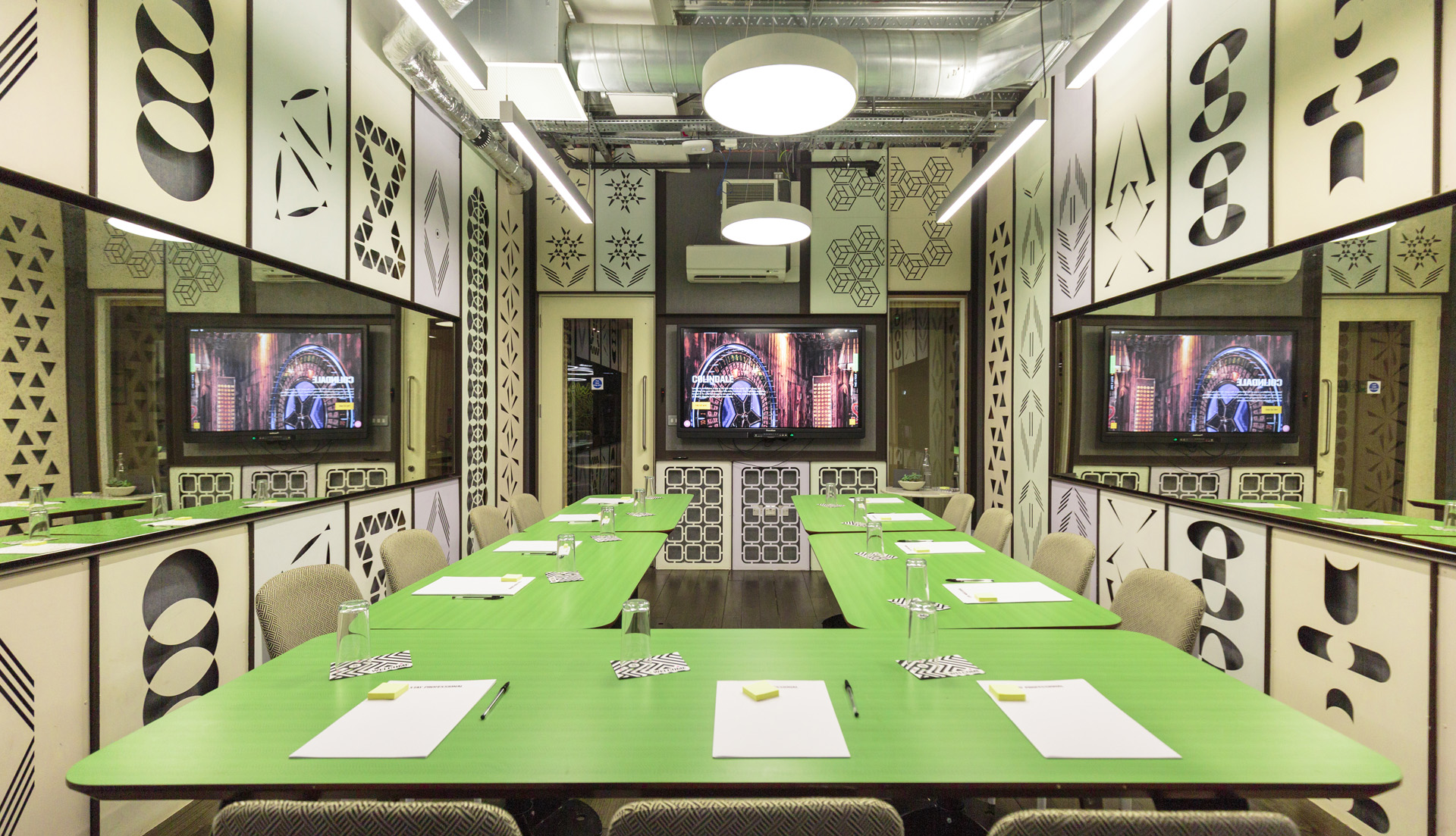 Modern meeting room with green tables for workshops at The Stay Club, Colindale.