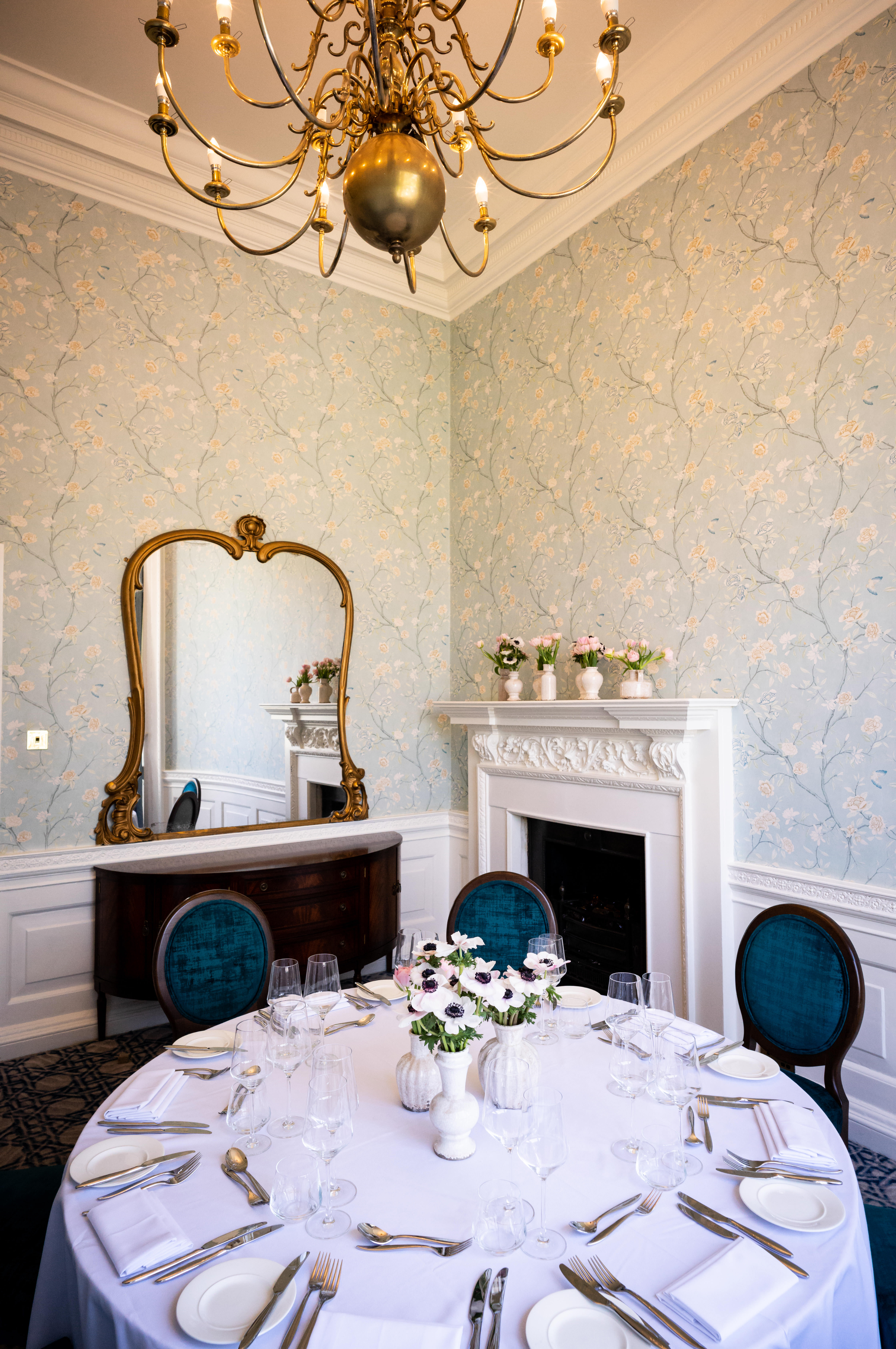 Elegant meeting space with vintage mirror and fireplace for intimate events.