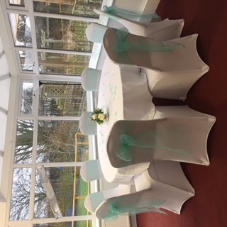 Iris Conservatory round table with aqua sashes, perfect for weddings and events.