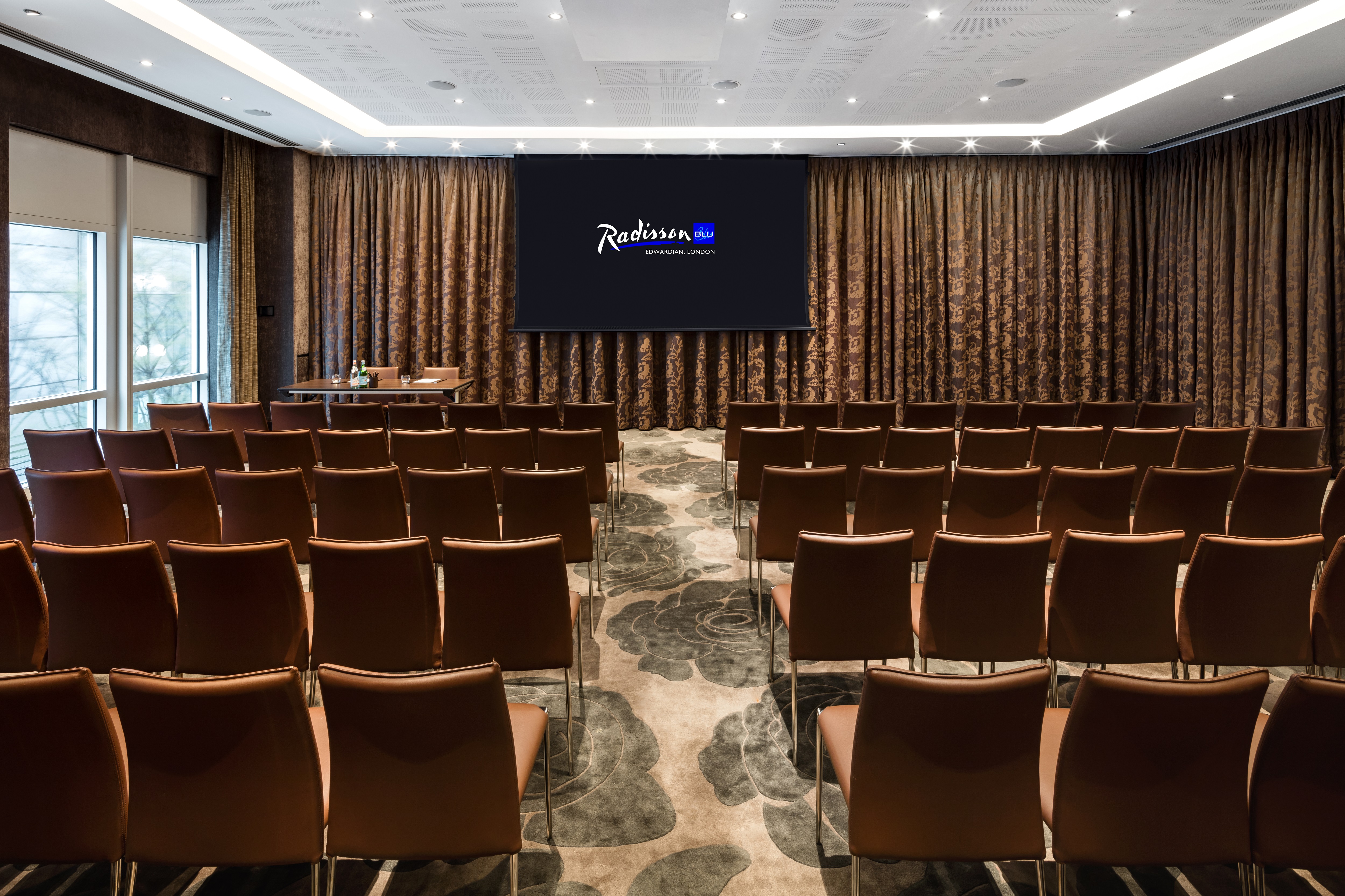 Meeting room at Radisson Blu, featuring theater seating and natural light for conferences.