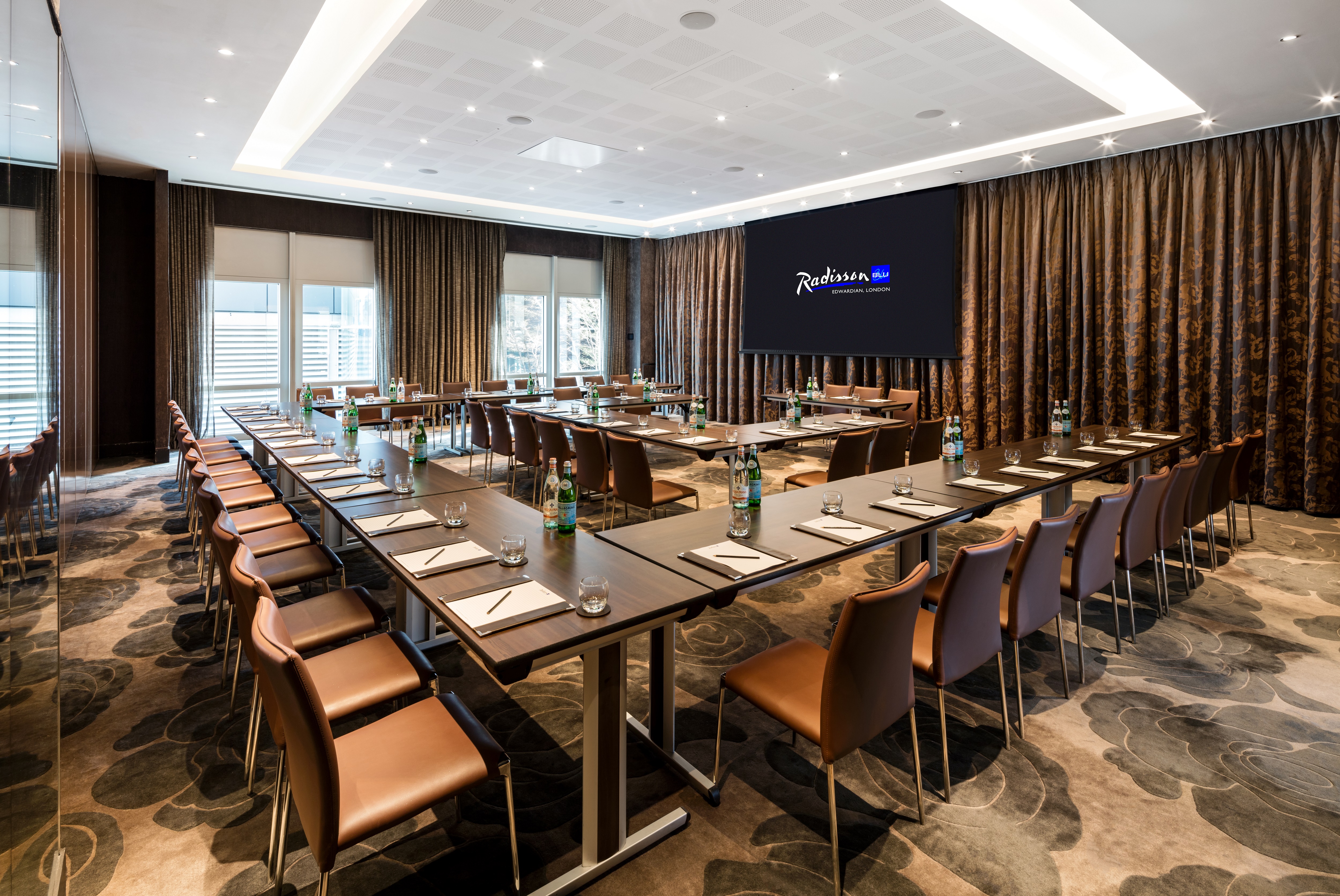 Meeting room at Radisson Blu, featuring a long table and modern AV equipment for events.