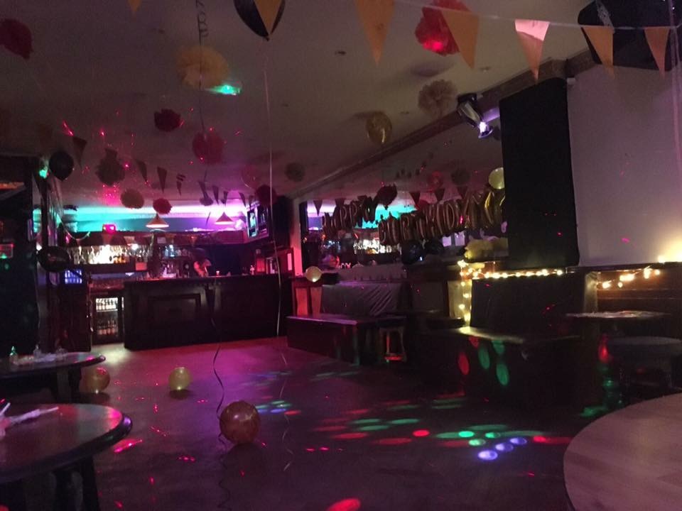 Vibrant event space at Moustache Bar Dalston with colorful lighting for celebrations.