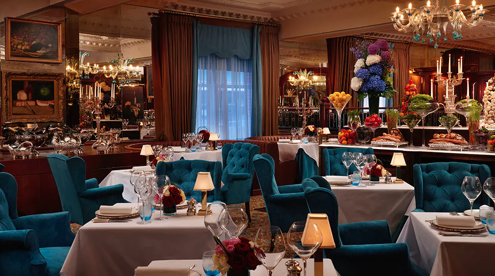 Elegant dining at The English Grill with plush turquoise seating for upscale events.
