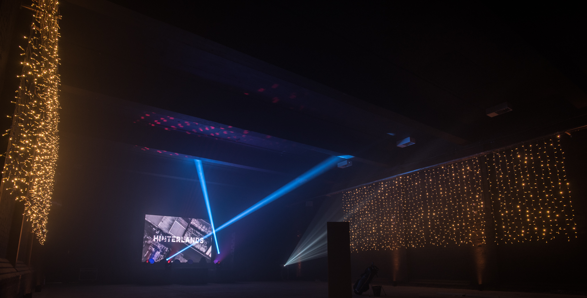 Eclipse Theatre in Hinterlands: vibrant event space with dynamic lighting and multimedia screen.