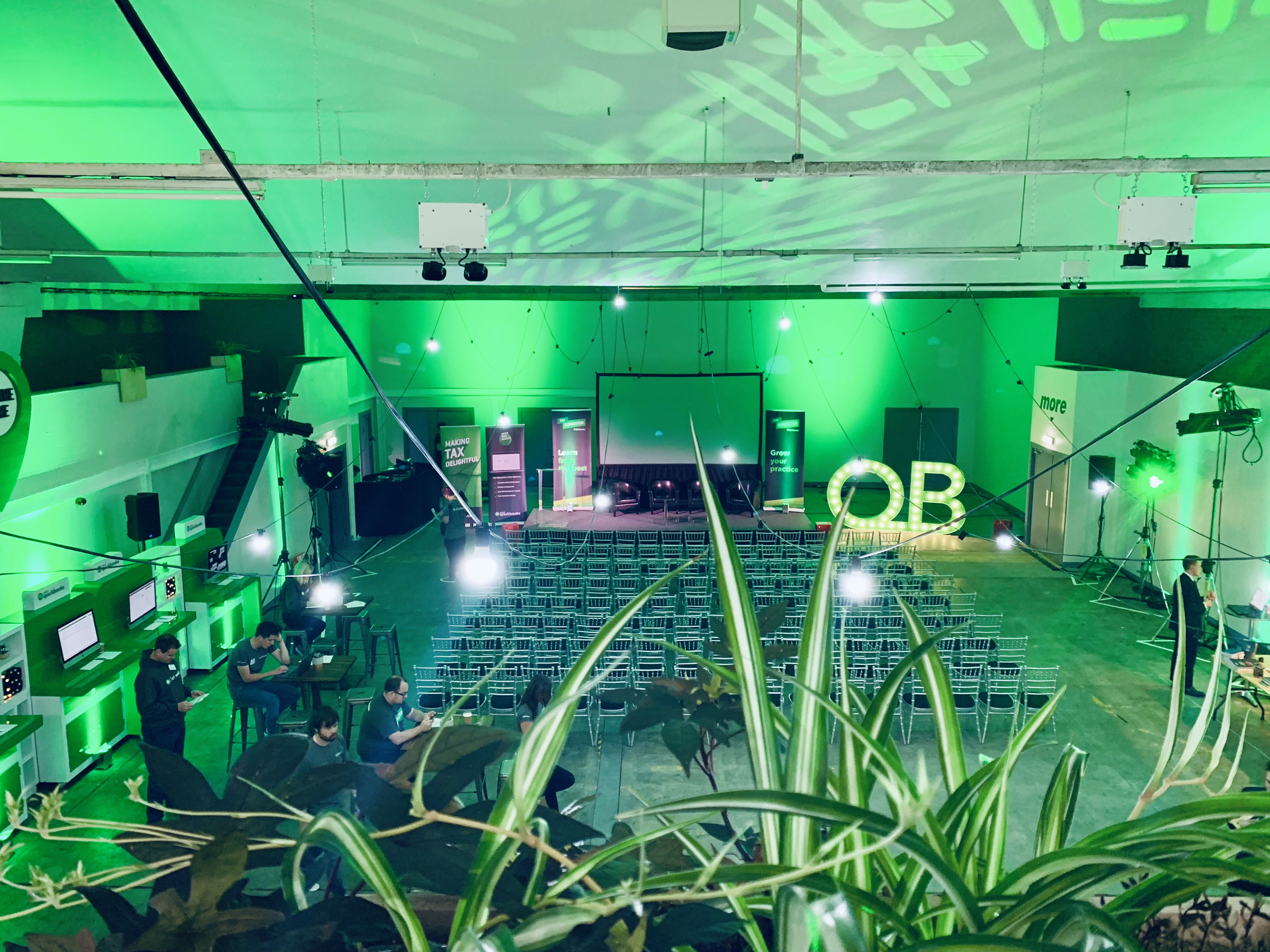 Event Hall in Hinterlands with green lighting set for a conference presentation.