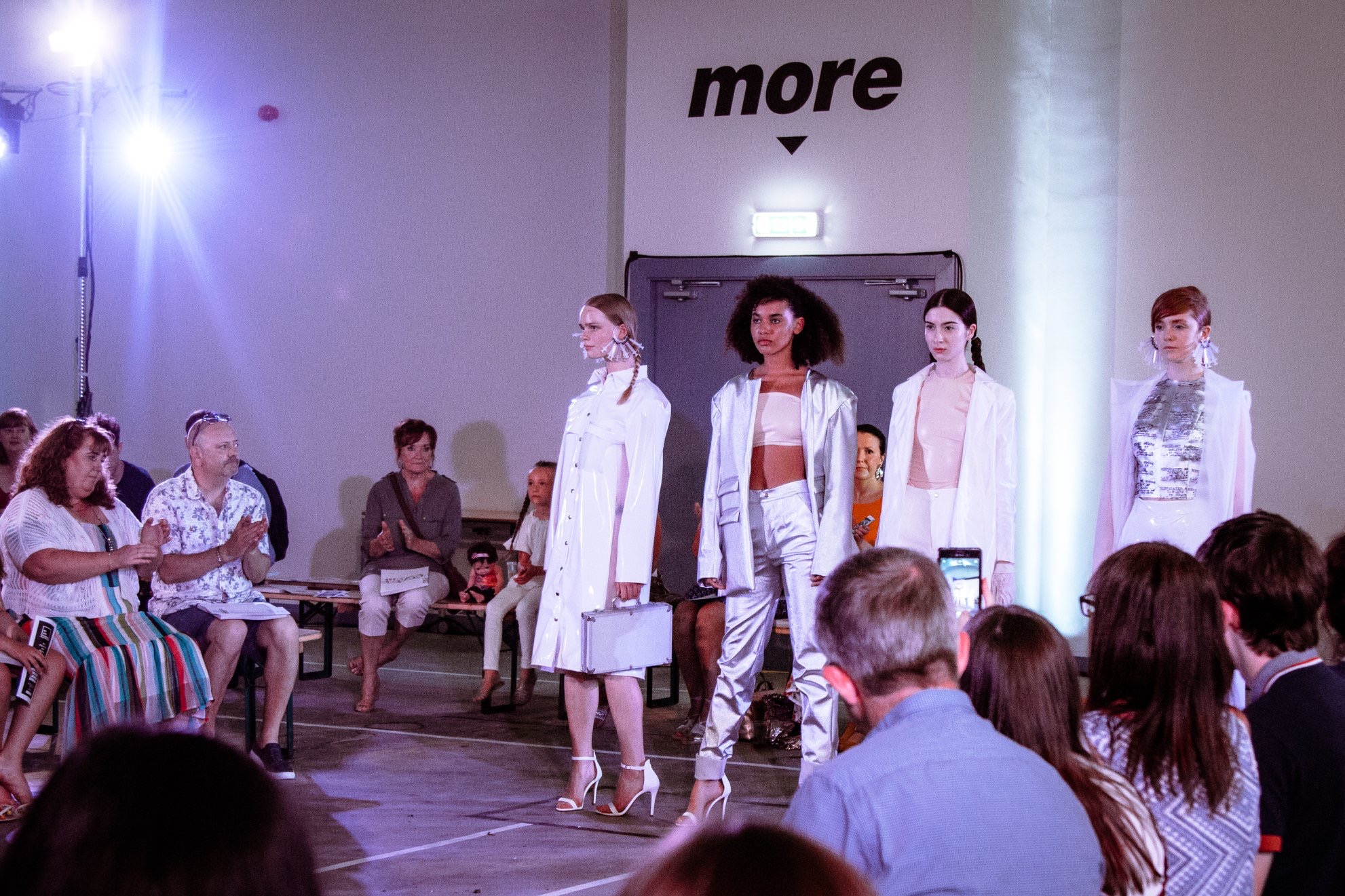 "Fashion runway event in Hinterlands' Event Hall with stylish models and engaged audience."