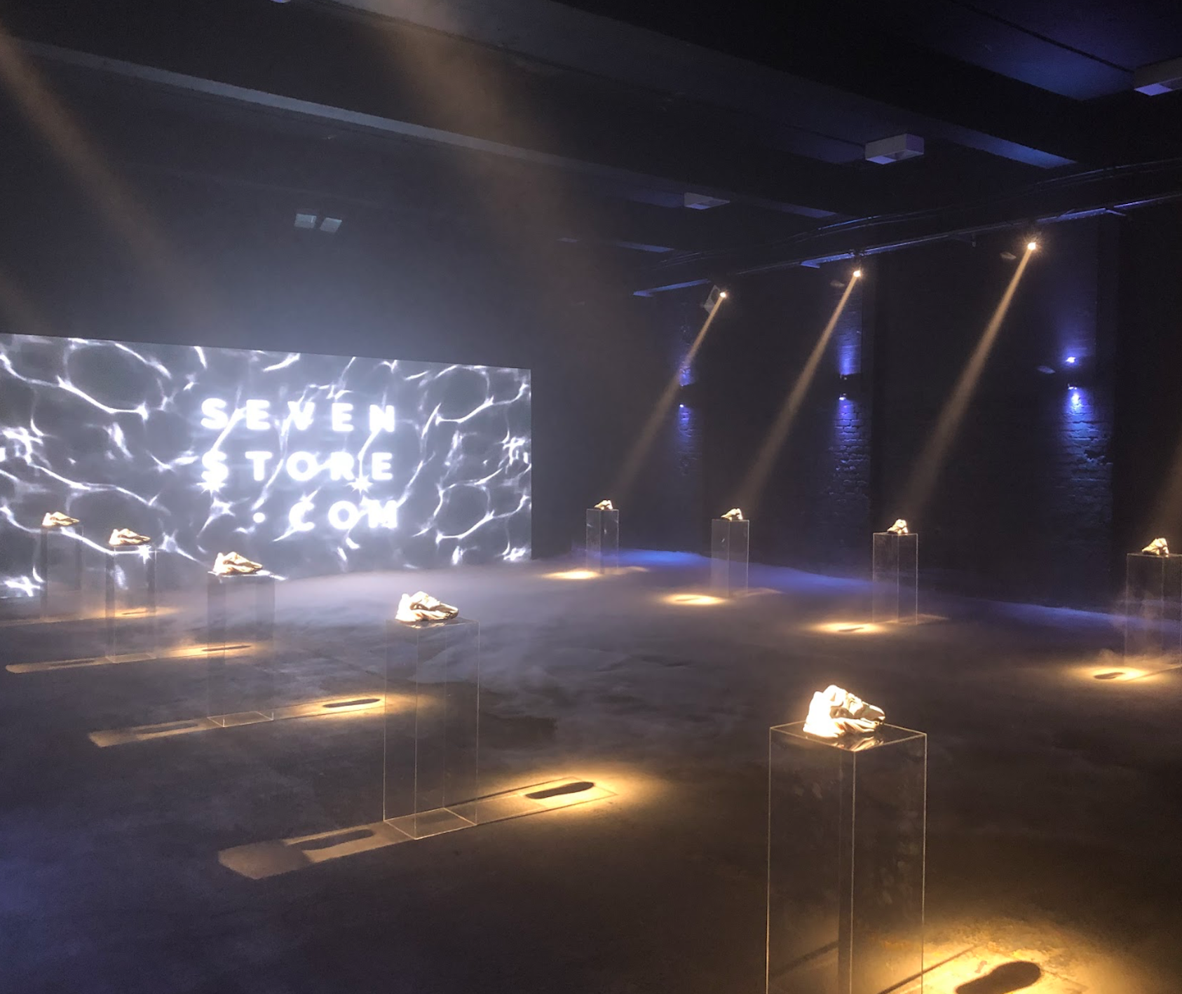 Sleek event hall showcasing "SEVEN STORE" backdrop and illuminated shoe displays.