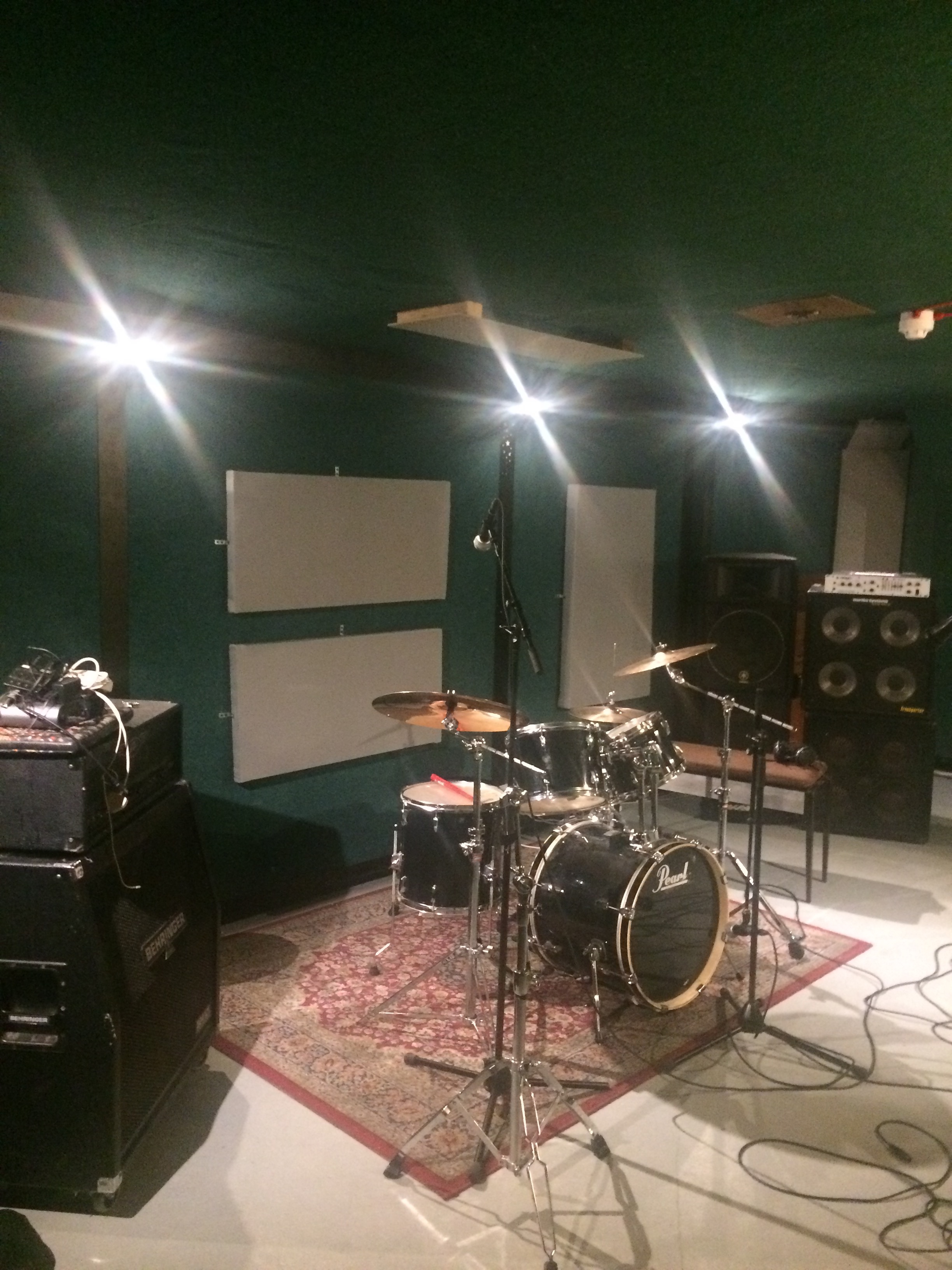 Soundproof rehearsal space with drum kit, ideal for live performances and workshops.