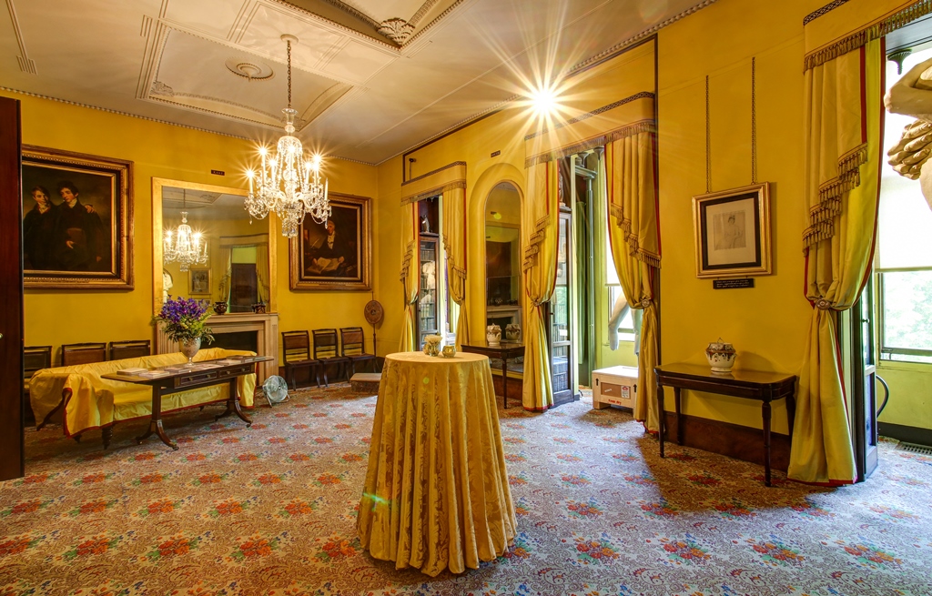 Elegant meeting space with yellow walls and chandeliers for corporate and social events.