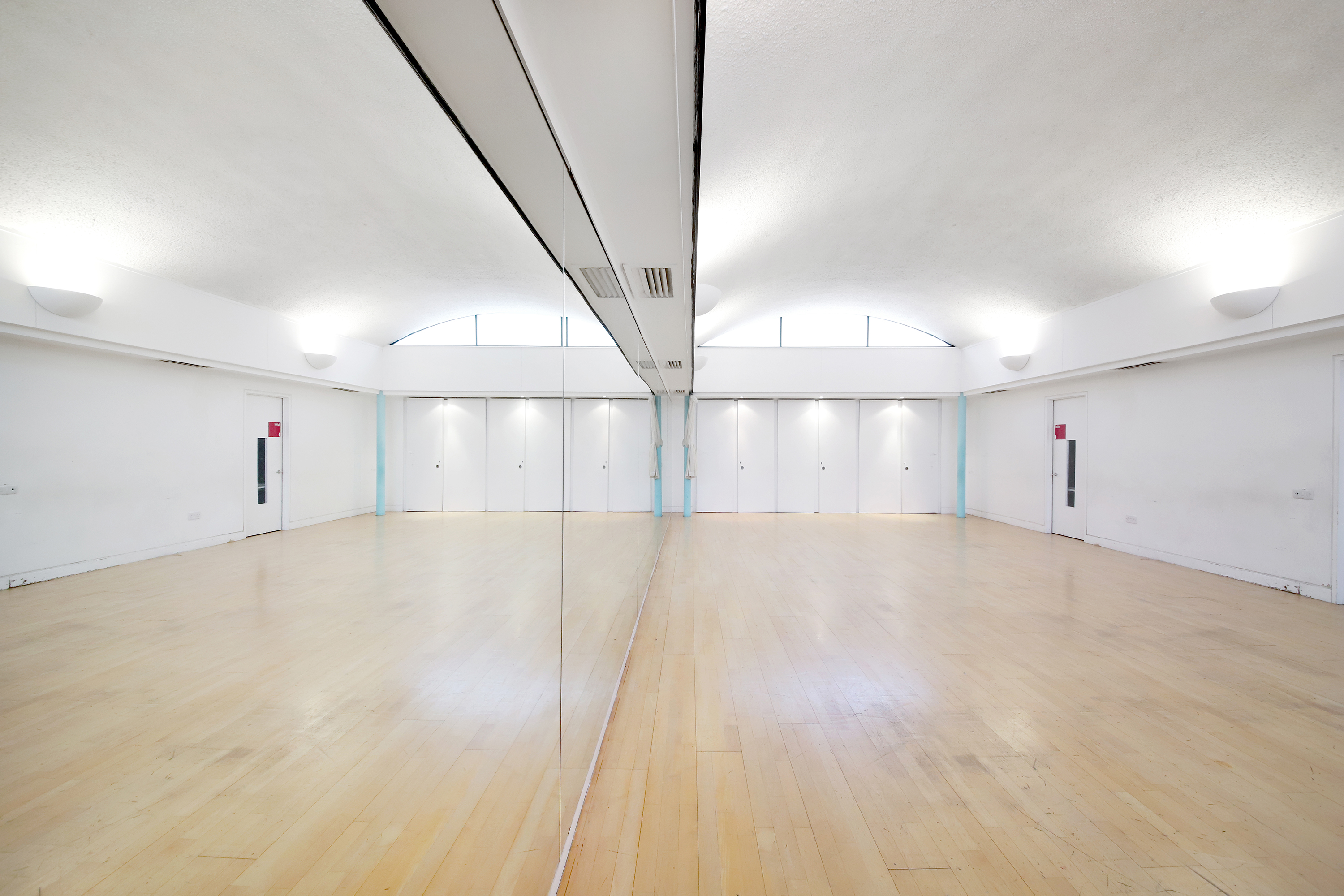 Spacious event space with polished wooden floors at Clean Break Studios for workshops and fitness.