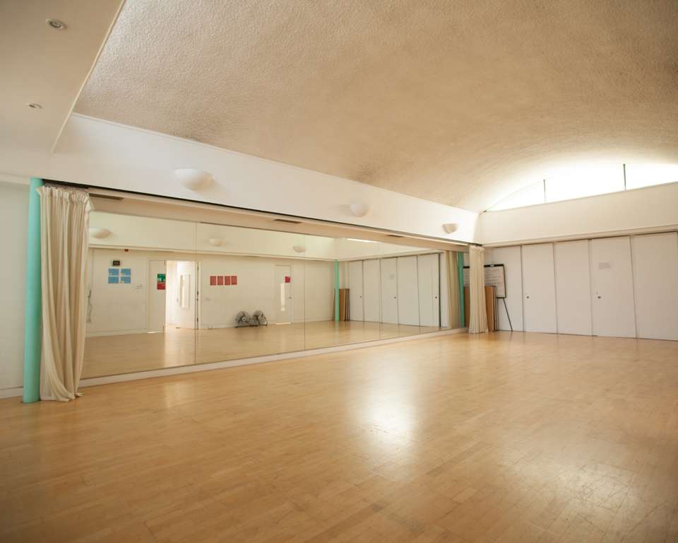 Spacious event space with mirrored wall for dance classes and workshops at Clean Break Studios.