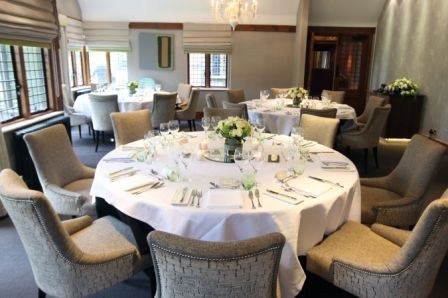 Elegant meeting space at Langshott Manor with round table and fresh flower centerpieces.