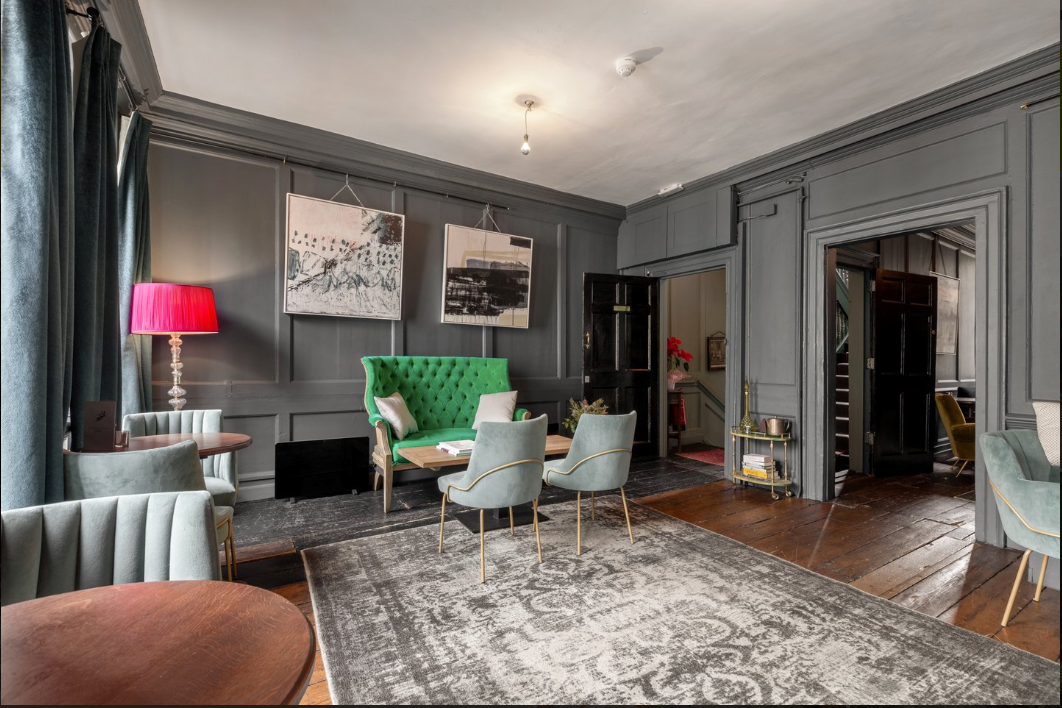 Stylish meeting space with green velvet sofa, perfect for workshops and networking events.