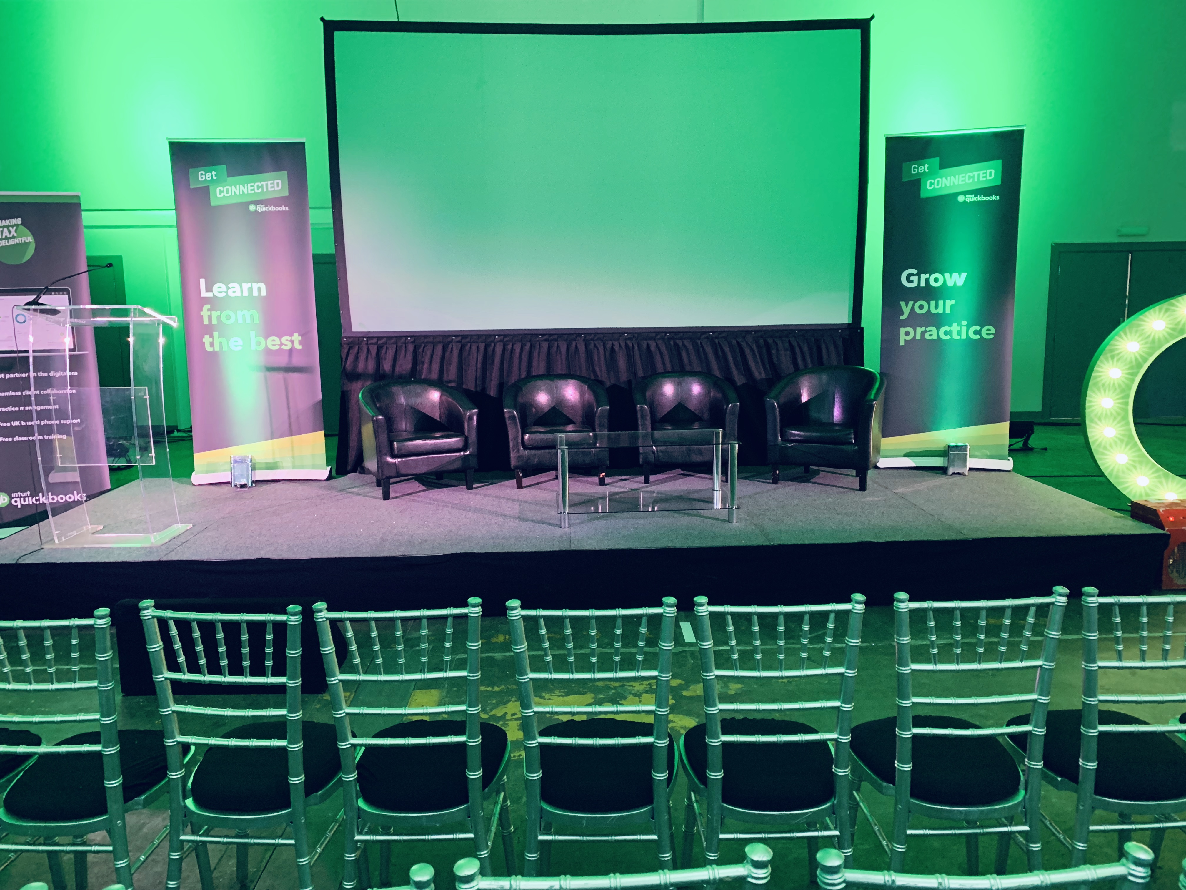 Eclipse Theatre event setup with sleek stage, green lighting for panels and discussions.