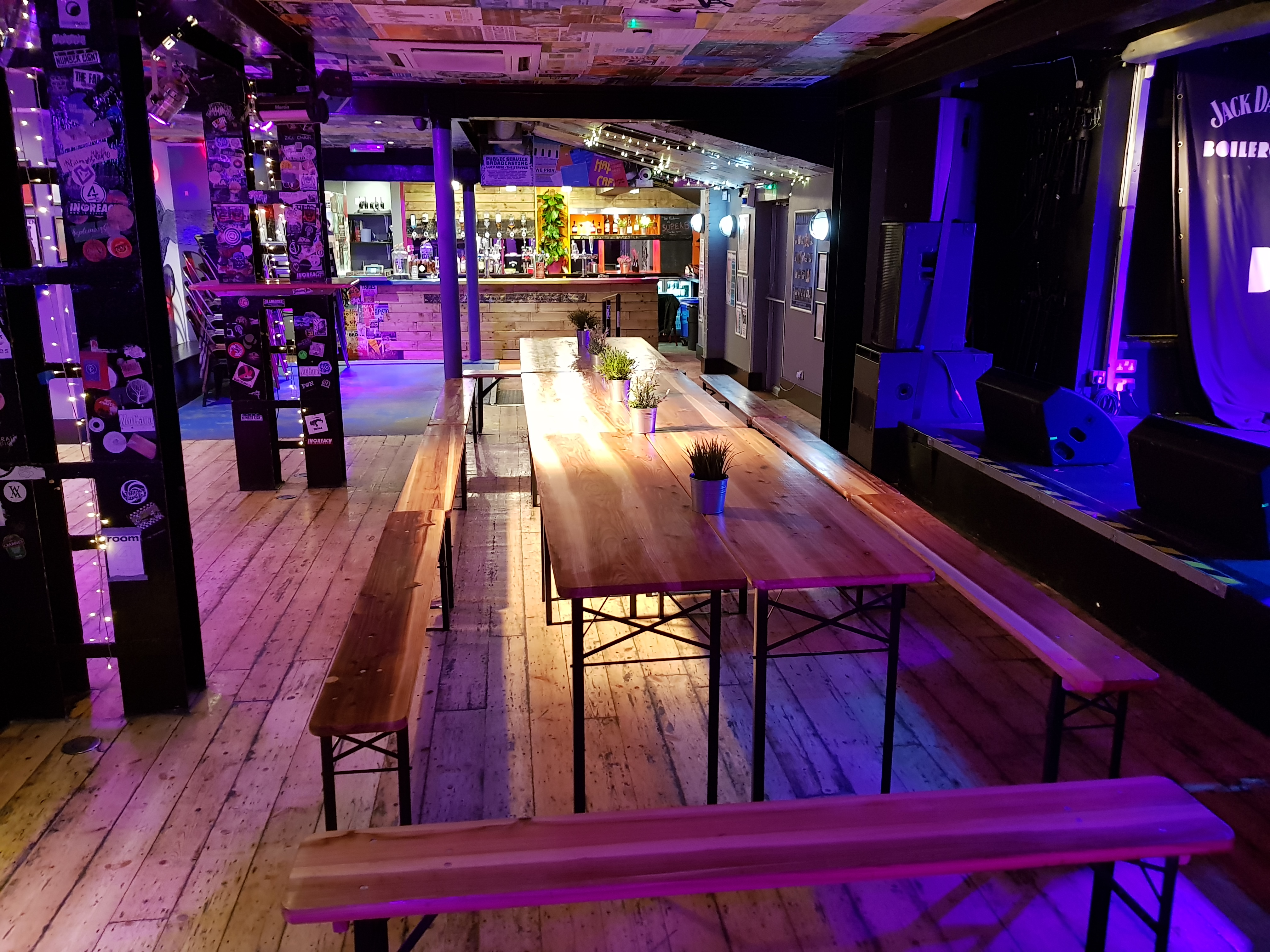 Main Room at The Boileroom: vibrant event space with communal seating for gatherings and performances.