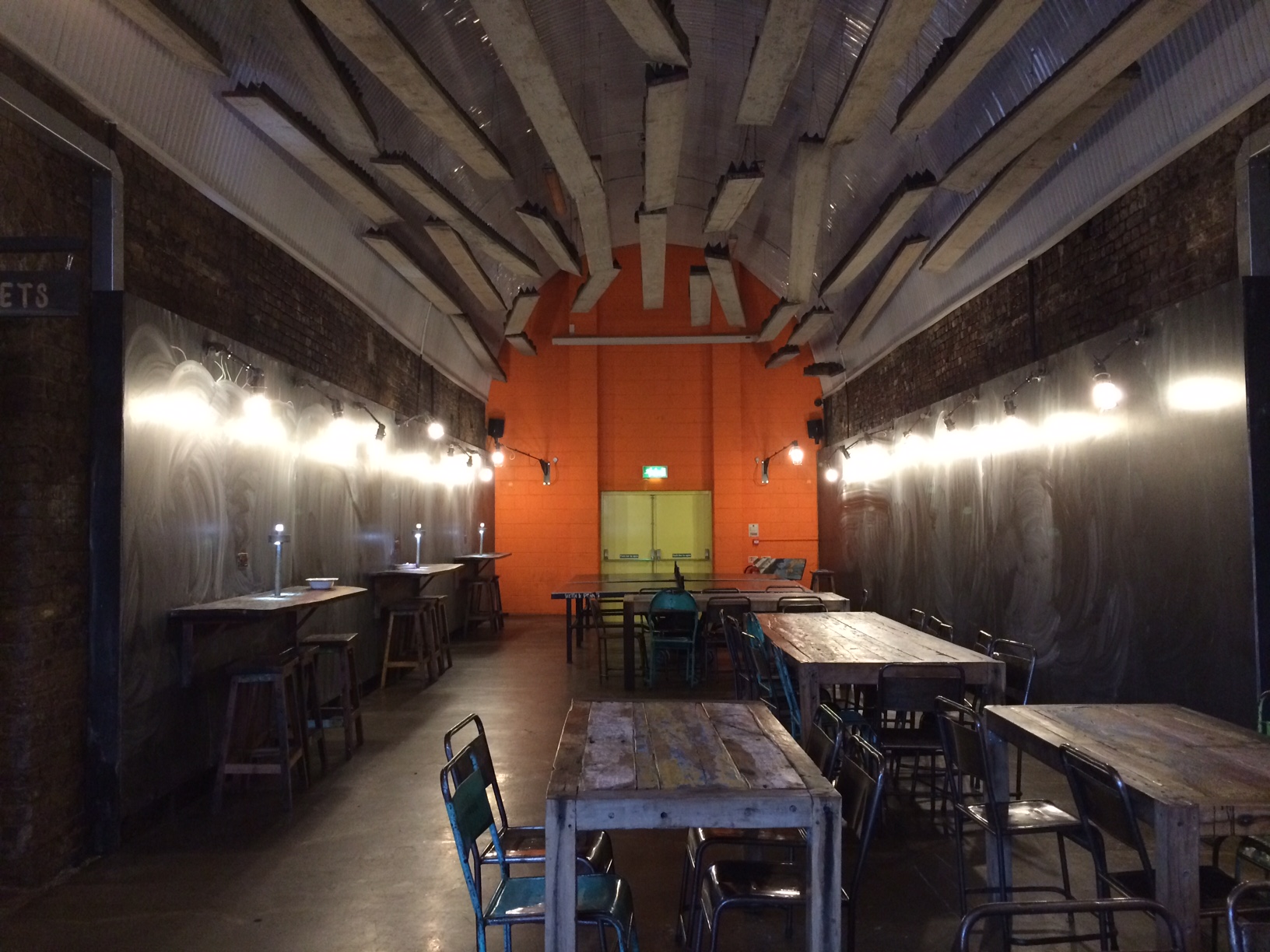 Versatile event space at The Doodle Bar, featuring exposed brick and warm lighting.