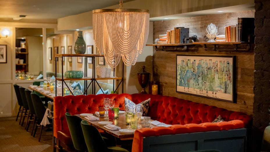 Stylish dining space with plush red banquette for intimate gatherings and corporate events.