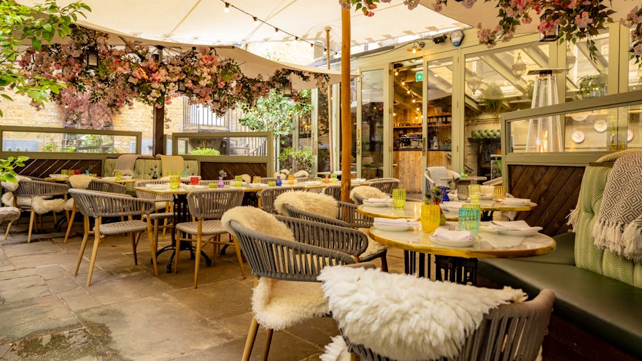 Outdoor dining space at Beaufort House Chelsea, ideal for events with lush floral decor.