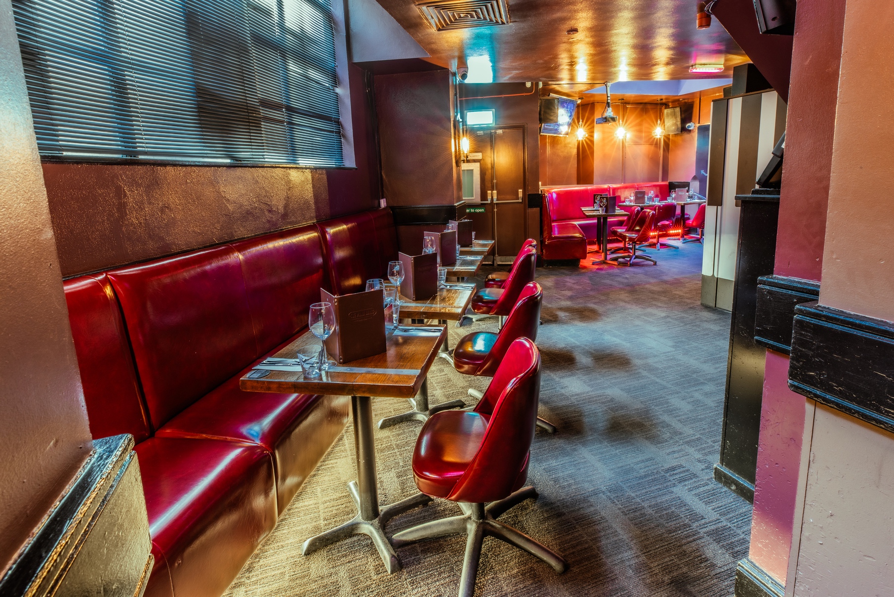 Stylish venue with plush red booths for intimate gatherings and networking events.
