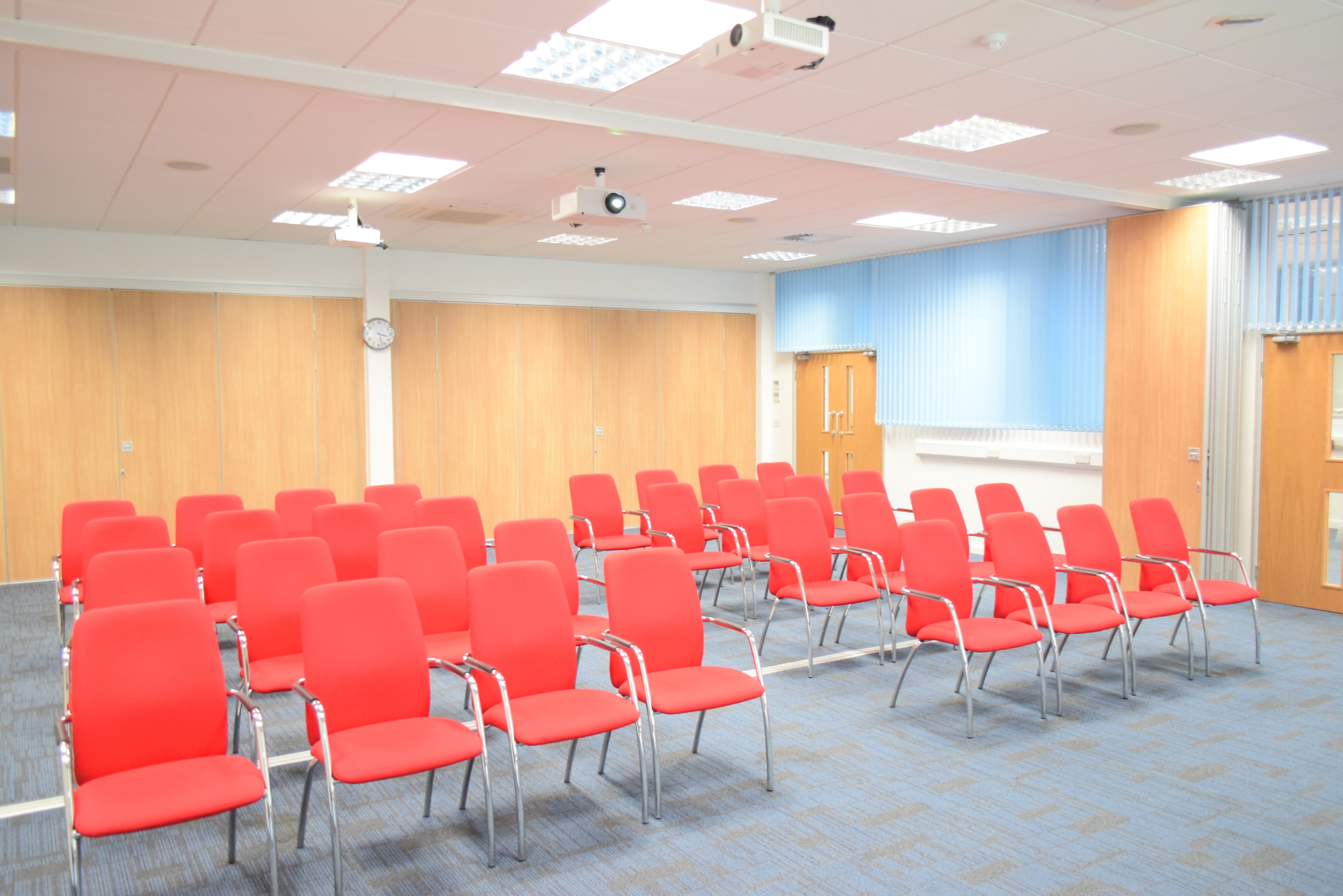 Conference room with red chairs and projector at Humanitarian Academy for Development.