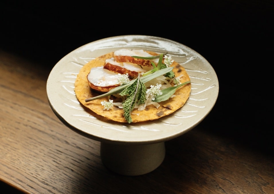 Elegant dish on textured tortilla, perfect for gourmet events and catering services.